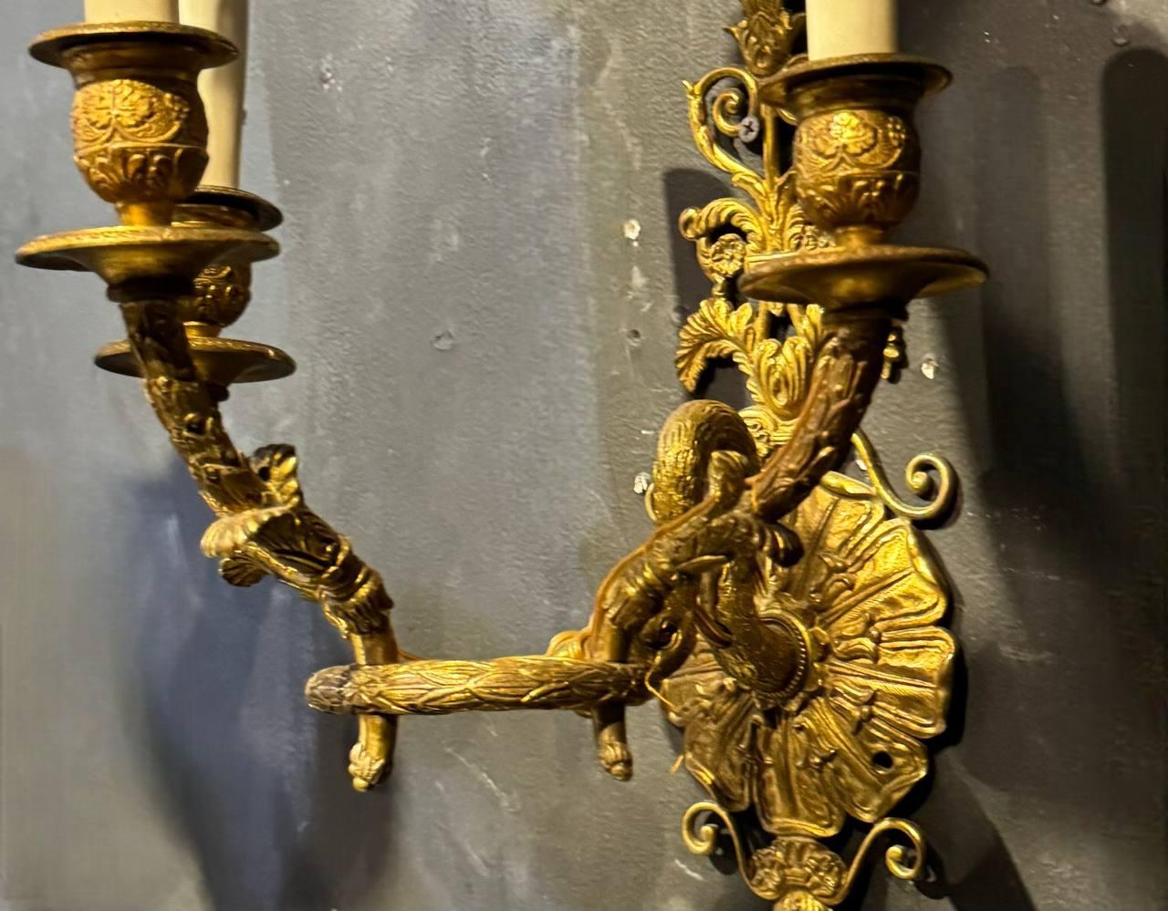 coppia di appliques Impero francese in bronzo dorato del 1920 circa con testa di cigno che regge un anello a 3 luci