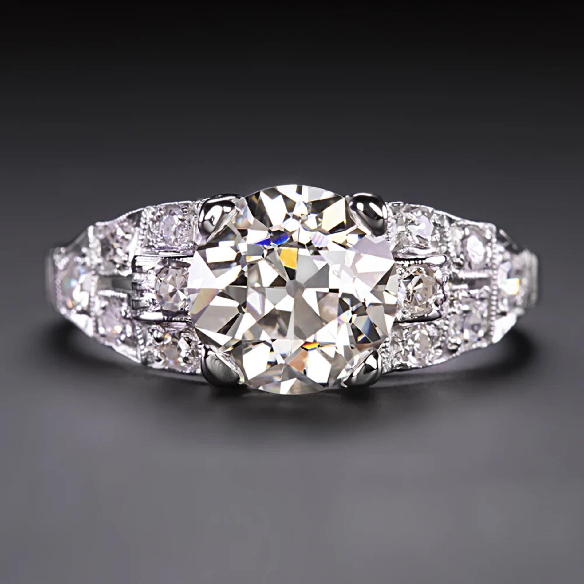 Dieser wunderschöne diamantene Verlobungsring besticht durch einen beeindruckend großen Diamanten im Übergangsschliff von 1,84 Karat in der Mitte und eine prächtige, mit Diamanten besetzte Fläche! Dieses handgefertigte Stück aus der Zeit des Art