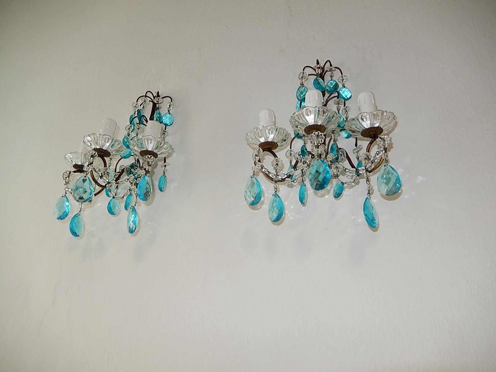 Housing three lights each, sitting in crystal bobeches. Will be rewired with certified US UL sockets for USA and appropriate sockets for all other countries and ready to hang.  Rare aqua blue crystal prisms, florets and swags of beads throughout.