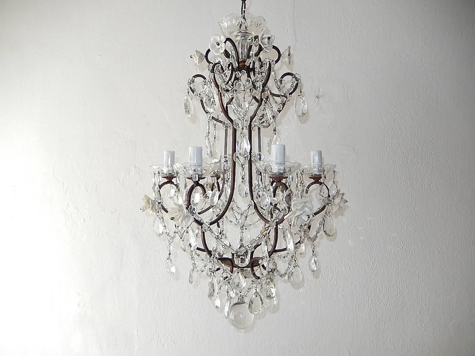 Housing six-light, sitting in crystal bobeches, dripping with vintage crystal prisms. Rewired and ready to hang. Dark patina metal frame with swags of crystal macaroni beads and prisms throughout. Adorning handmade French white porcelain roses and