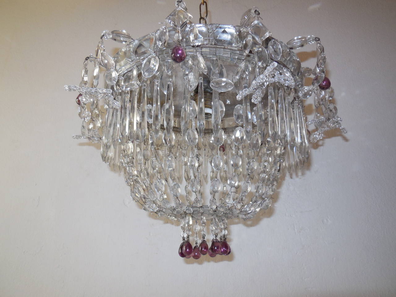 Housing 1 light. Swags of vintage crystals springing from top. Basket bottom with huge crystal prisms finial. Rare huge square prisms and beads encircling the top with rare long crystals. All crystals are hand twisted together. Adorning small