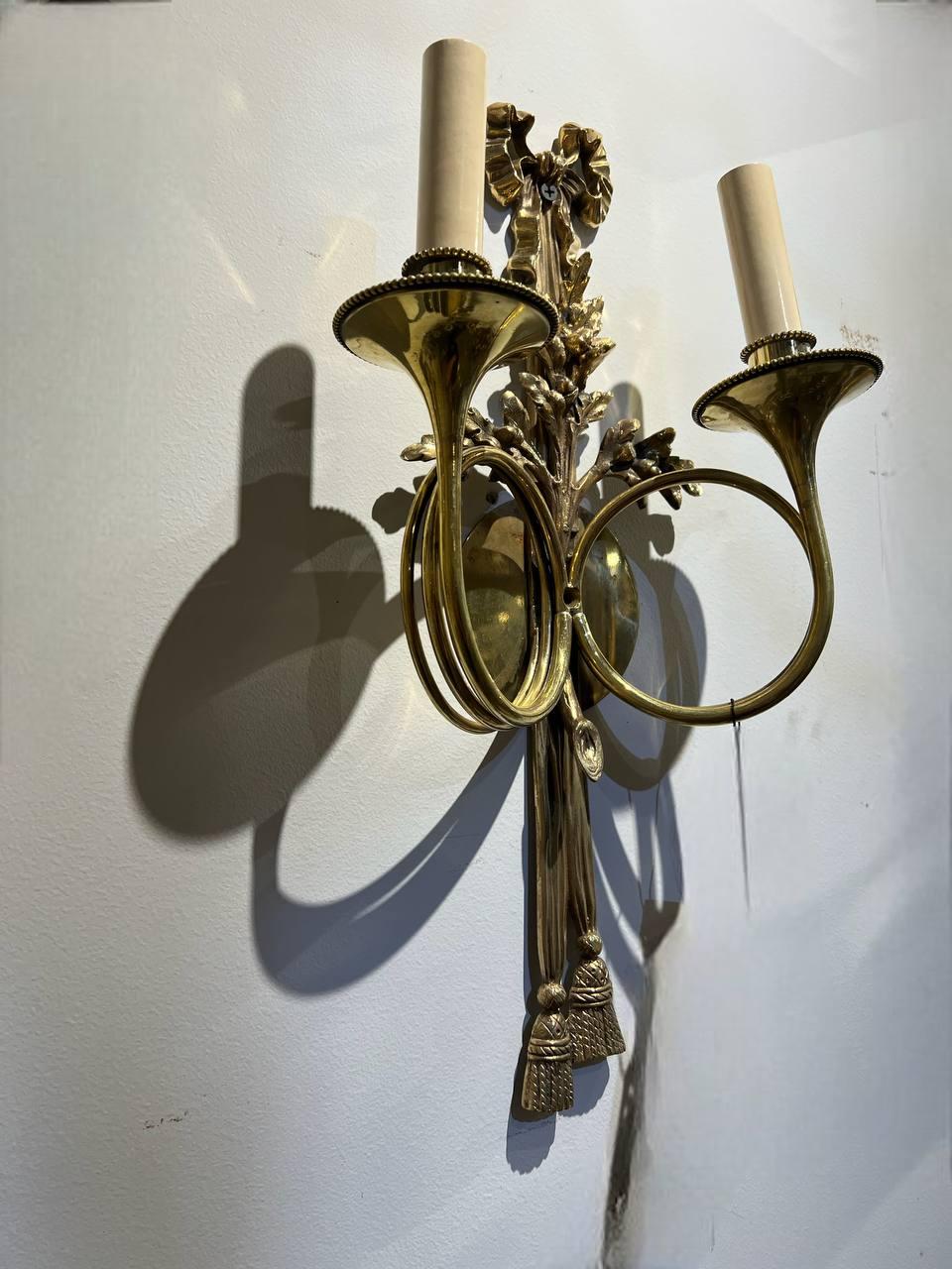A pair of circa 1920’s French gilt bronze double lights sconces wit ribbon and twisted arms