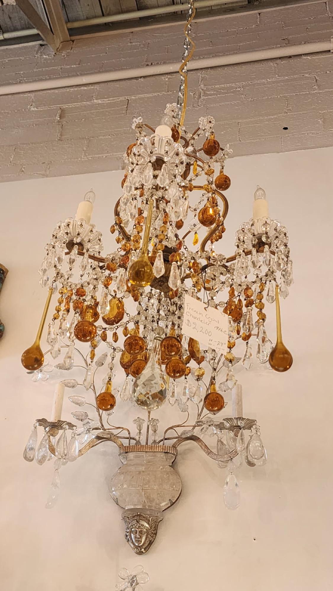 Questo annuncio presenta un lampadario in cristallo champagne, arancione e trasparente che molto probabilmente proviene dalla Francia negli anni '20. Questo lampadario ha varie gocce di vetro arancione e color champagne e bagliori di vetro