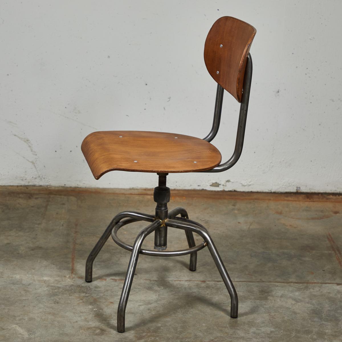 1920 French wood and metal swivel chair. Chair with a curved seat above ringed and spider legged base (five chairs available).