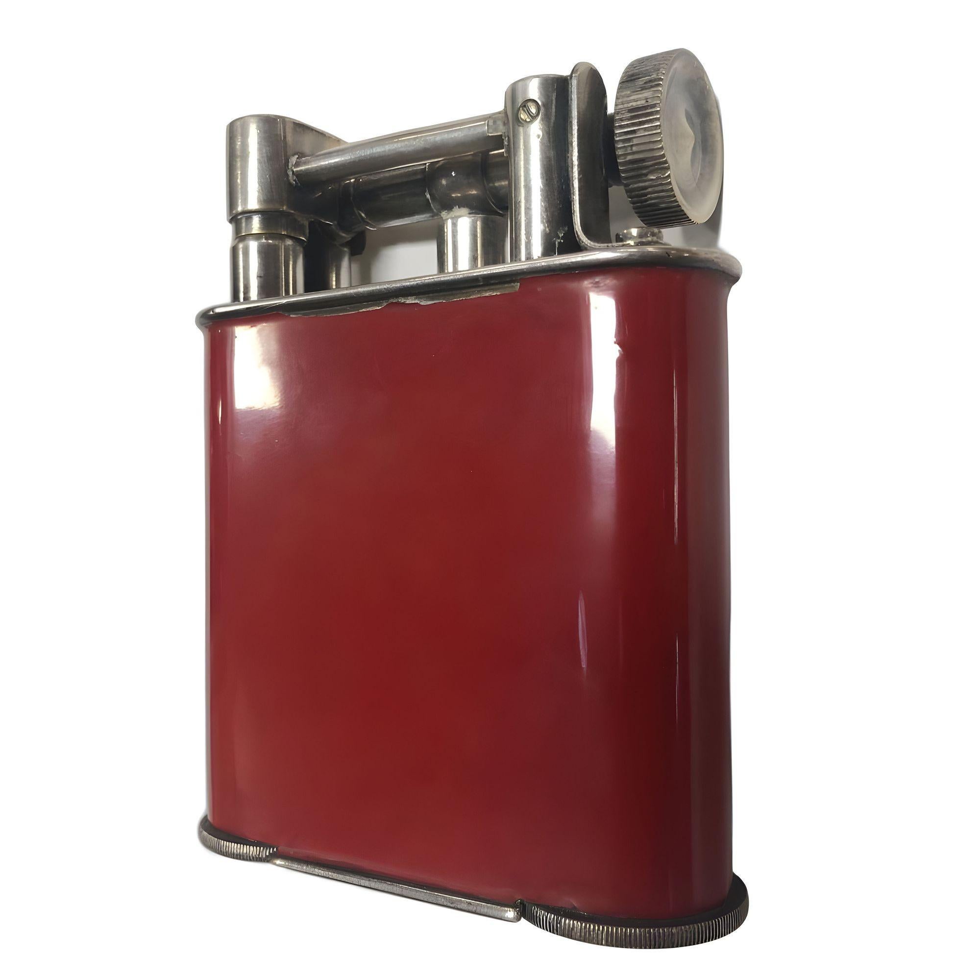 Original late 1920s red enamel tabletop lighter features a classic lift arm design Made in France. This large tabletop lighter is in working order and is sure to add class to any room.

Stamped 