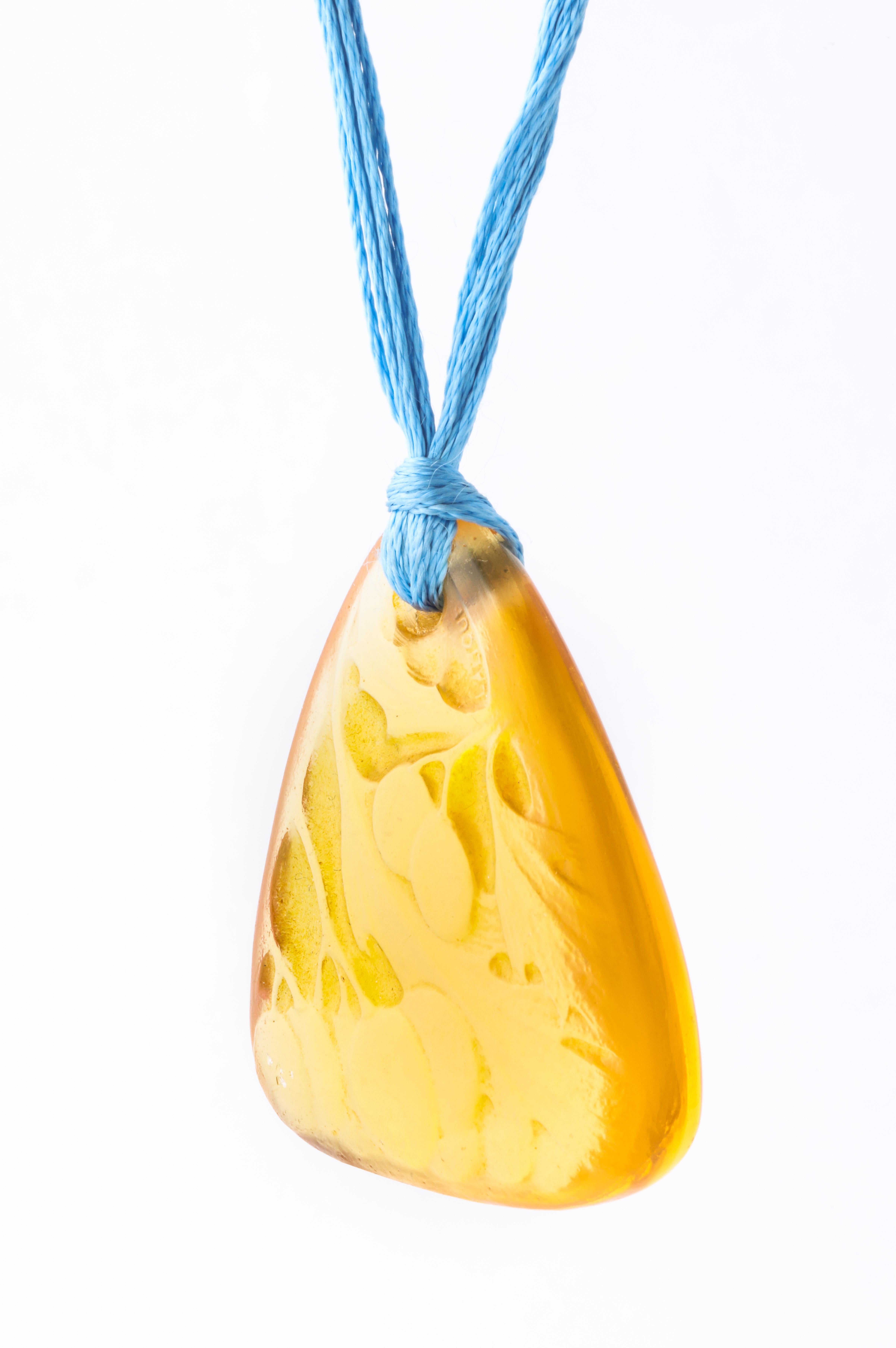 An amber glass pendant titled 