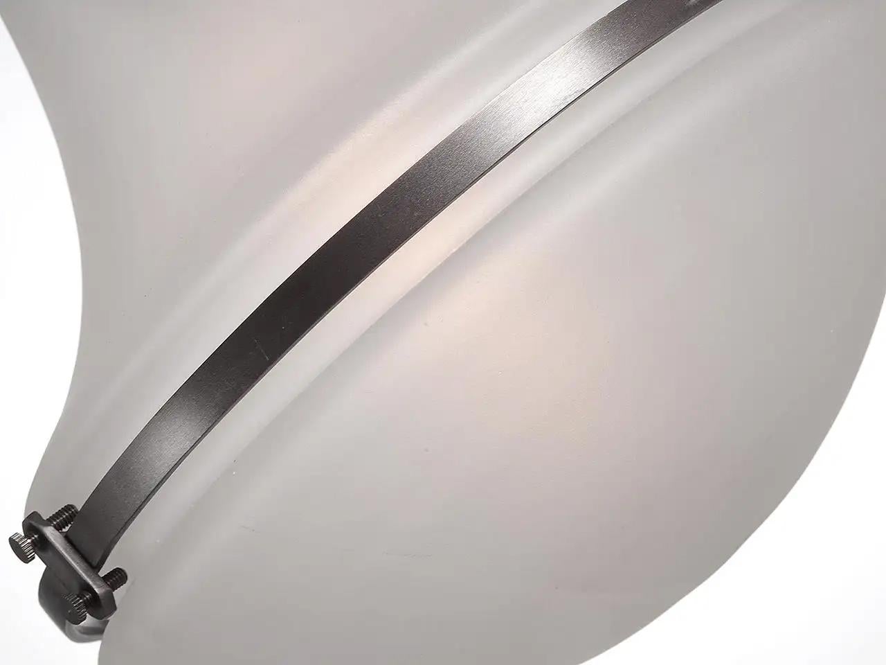 Questo nuovo pendente in stile Luzette è stato ispirato dal classico design di Peter Behrens del 1920. Il vetro è satinato e tutte le parti metalliche sono in ottone scuro. Rifiniamo e cabliamo a mano ogni lampada in base alla lunghezza della tua