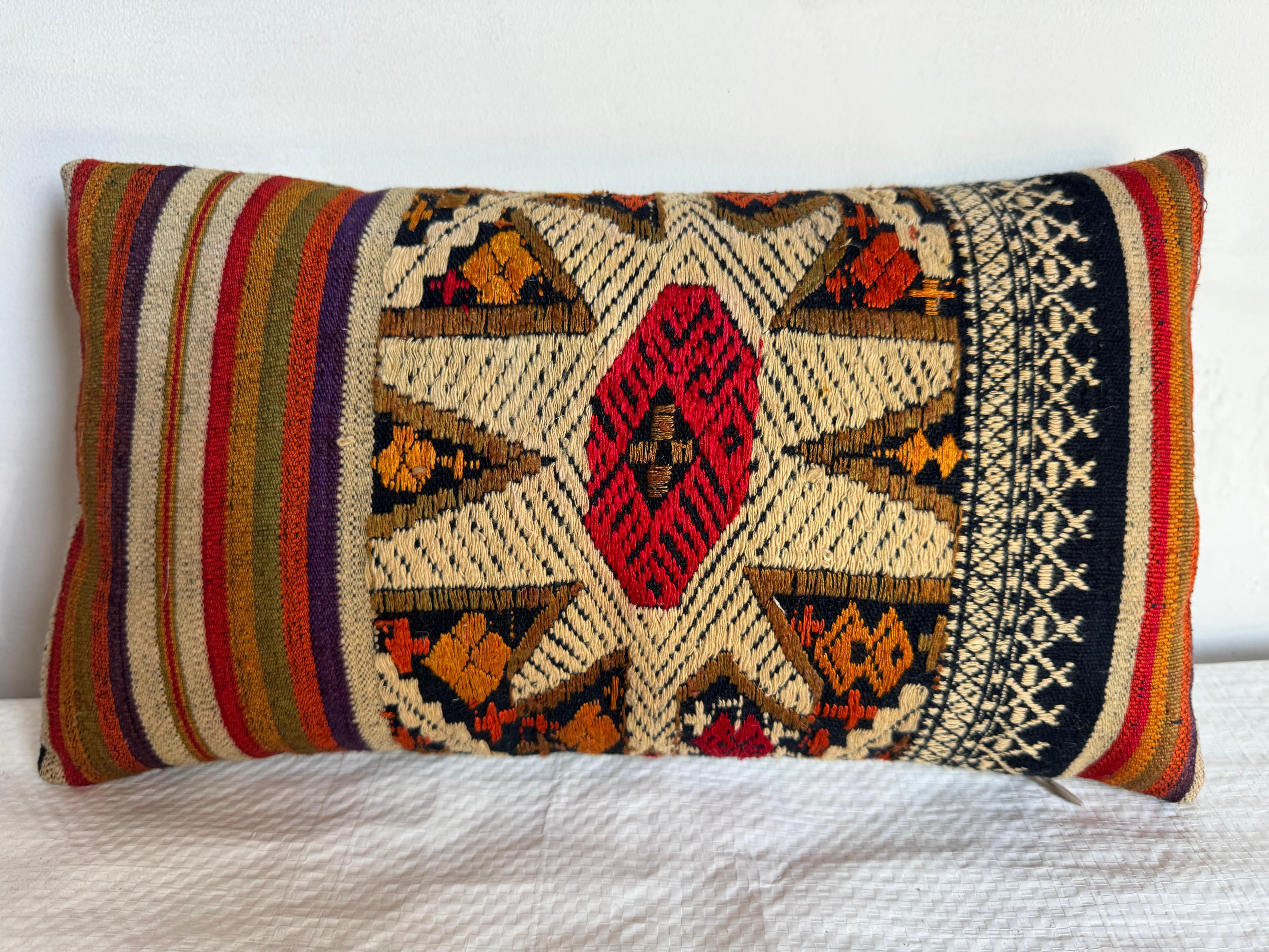 Audace e colorato, questo cuscino Suzani del 1920 dona un tocco di eleganza bohémien a qualsiasi ambiente. Caratterizzato da motivi geometrici e strisce tradizionali nei colori rosso, oro e blu, incarna la vivacità dell'artigianato.
Misurando 14