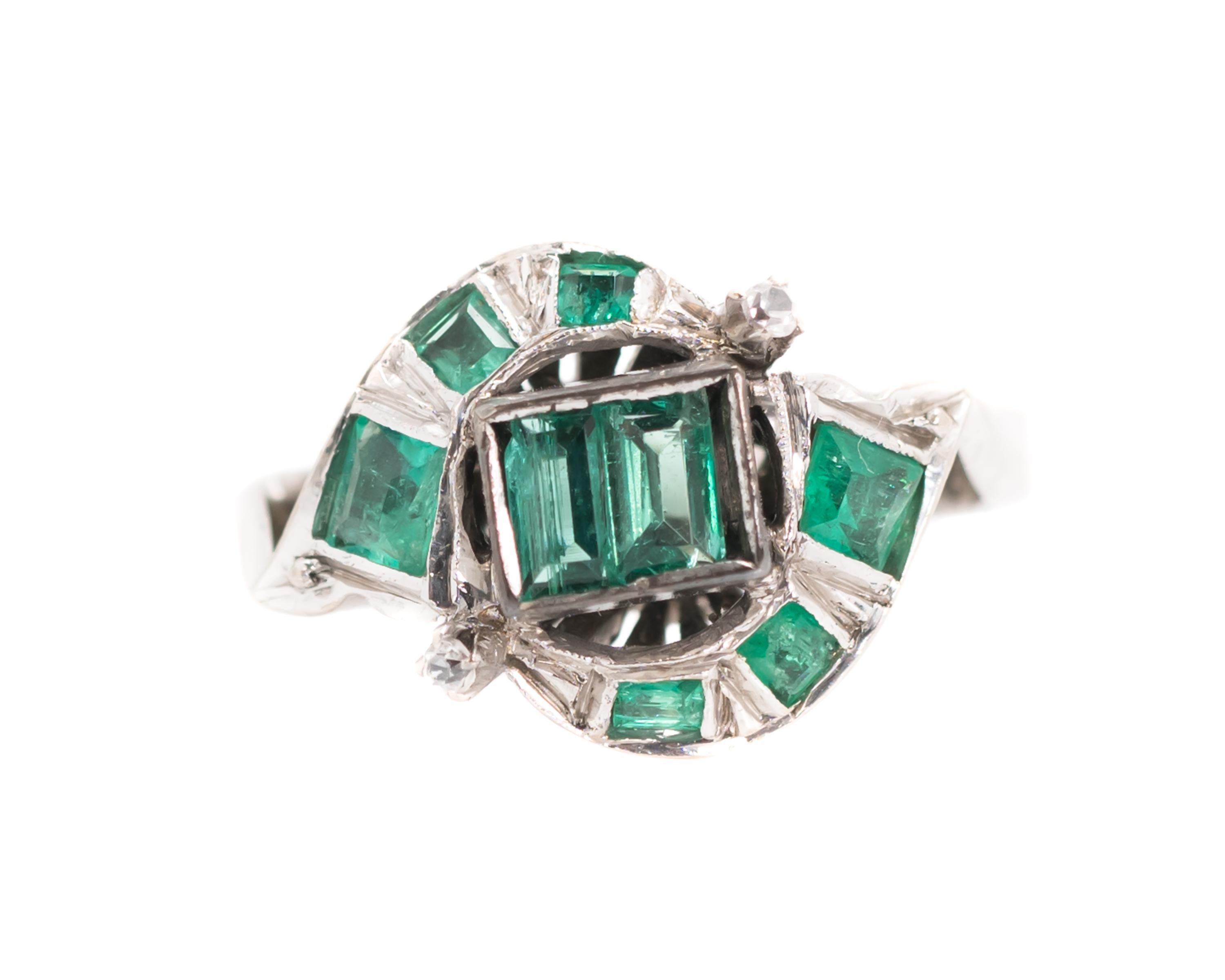 1920s Art Deco Bypass Ring - 18 Karat White Gold, Colombian Emeralds, Old Mine cut White Sapphires

Features 0.75 Carats Colombian Emeralds set in 18 Karat White Gold. A pair of Emerald cut Emeralds are bezel set at the ring's center. 6 more