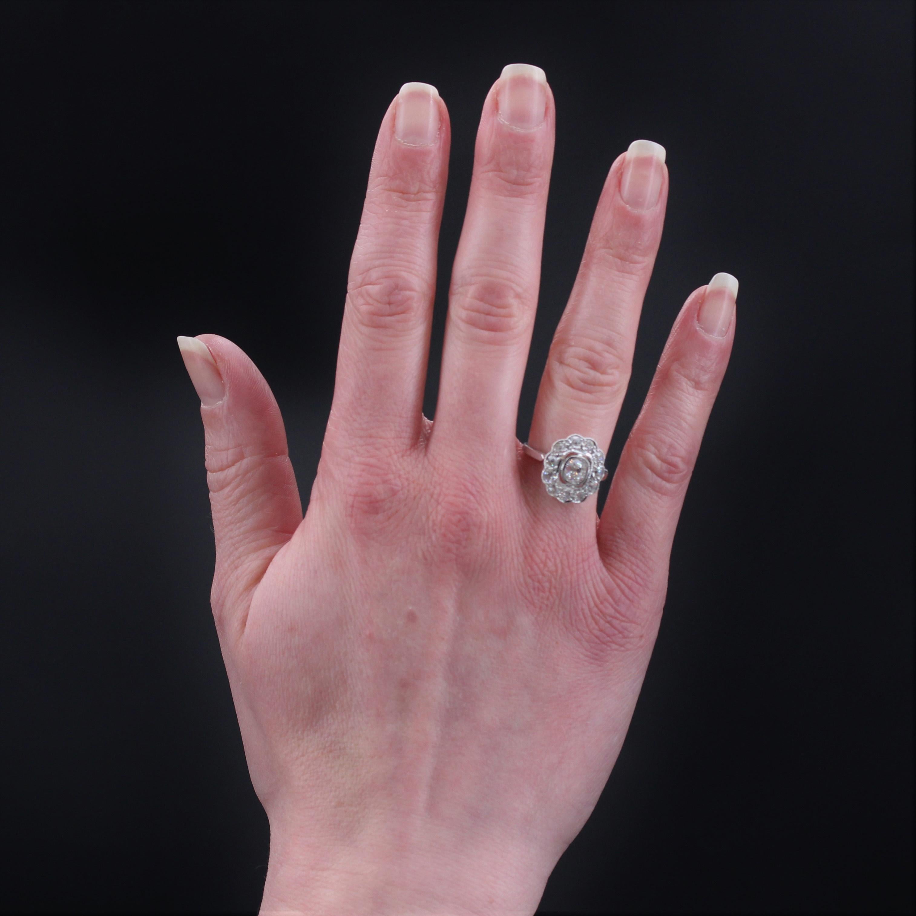 Ring in platinum.
Charming antique daisy ring, its setting is moved like a flower and decorated with brilliant- cut diamonds and antique cushion- cut diamonds all around. In the center, a more important cushion-cut diamond is set in a closed