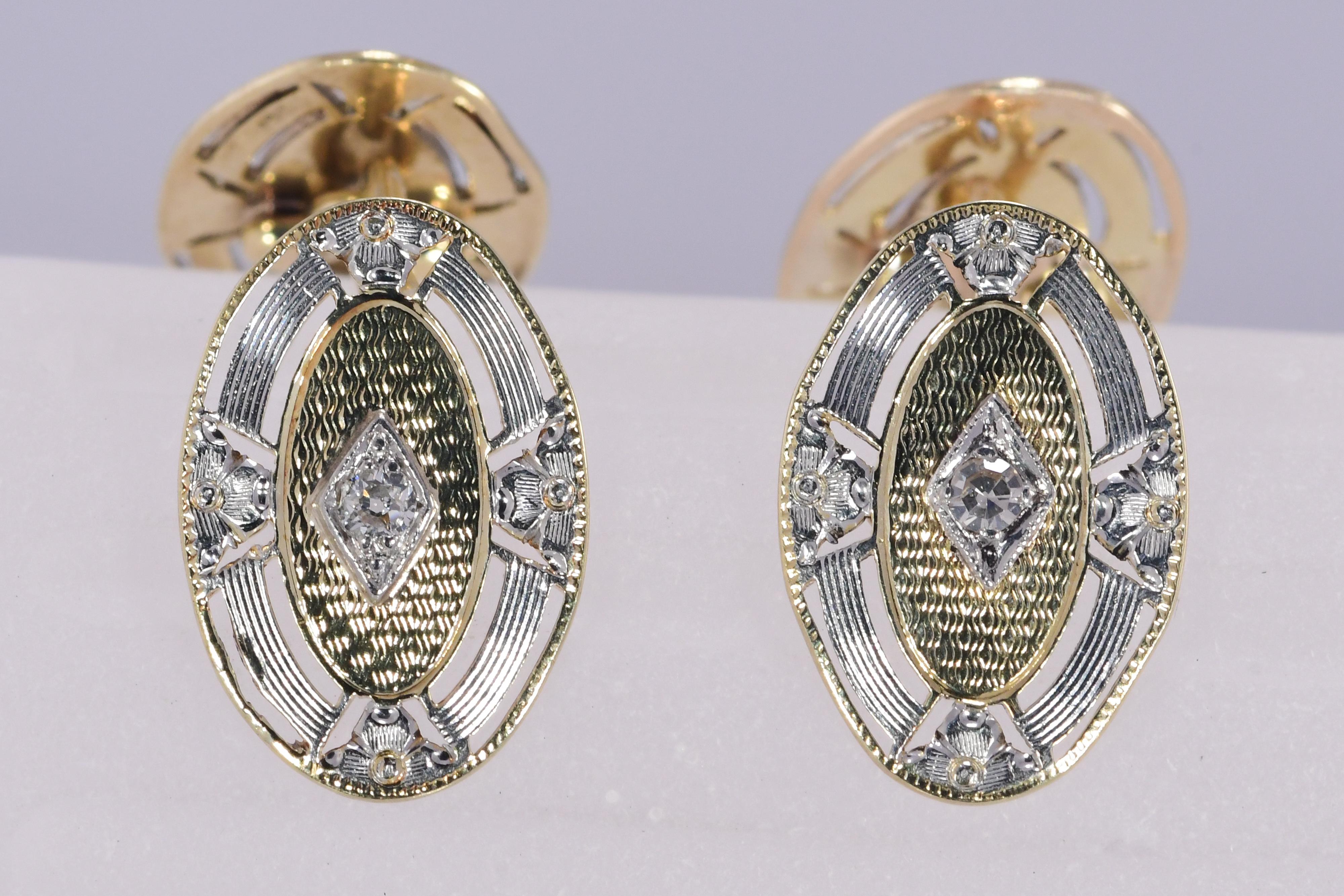 Vintage Art Deco 1920's 14 karat yellow and white gold diamond cuff links. The oval shape cuff links have detailed open work and geometric patterns. 
The length and width is 3/4 inch by 1/2 inch. The diamond weight totals .08 carat. The Weight is