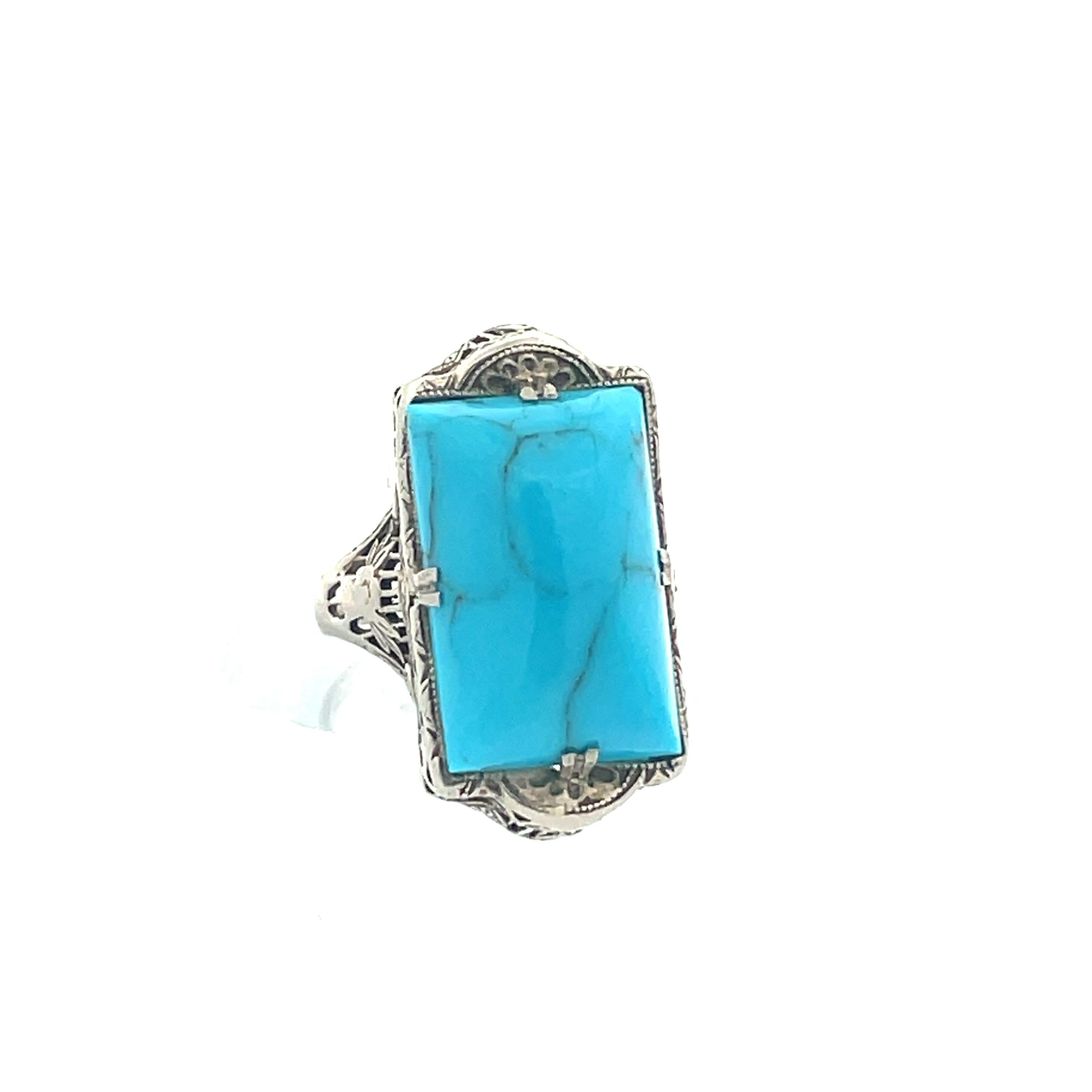 This beautiful 1920s14k white gold filigree ring features a cabochon cut turquoise stone, reminiscent of clear Caribbean blue waters with natural beauty and striking colors. Turquoise pairs beautifully with various precious metals as well as other