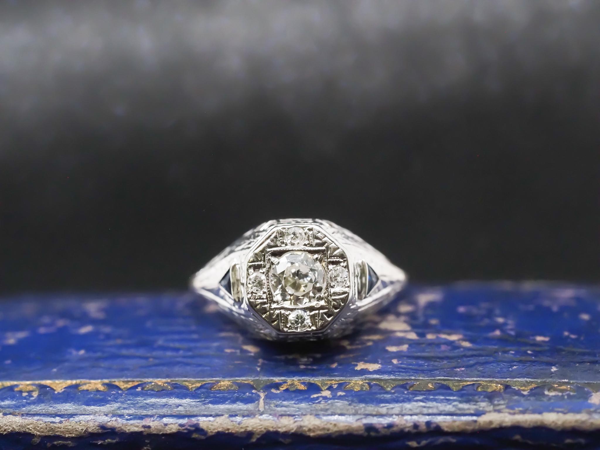 Year: 1920s

Item Details:
Ring Size: 6 (Sizable)
Metal Type: 14K White Gold [Hallmarked, and Tested]
Weight: 2.8 grams

Diamond Details: .30ct, Old European Brilliant, J Color, VS Clarity

Side Stone Details: .08ct, Old European Brilliant, J Color,