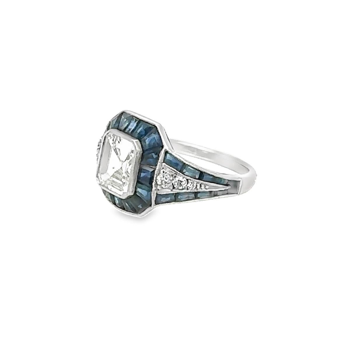 Step into the dazzling world of the 1920s, where elegance and opulence were celebrated in every facet of life. Our exquisite 1.50 carat emerald-cut diamond ring, flanked by meticulously calibrated blue sapphires, is a true testament to the height of