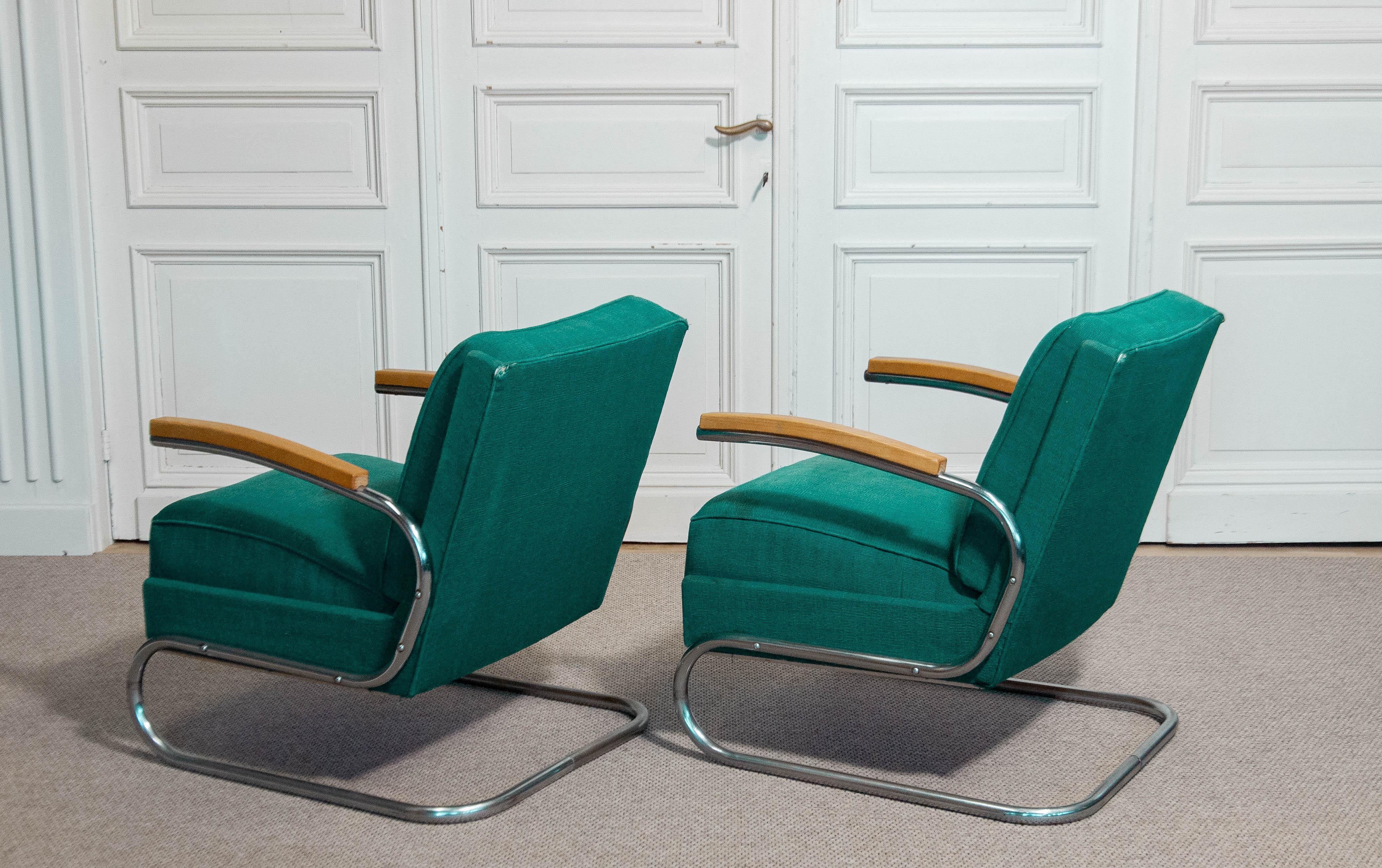 Pair of Bauhaus-style lounge chairs by Mücke & Melder, dating from the 1920s–1930s. Featuring original green upholstery in vintage condition with visible signs of age including some stains and small holes. The chrome tubular steel frame remains in