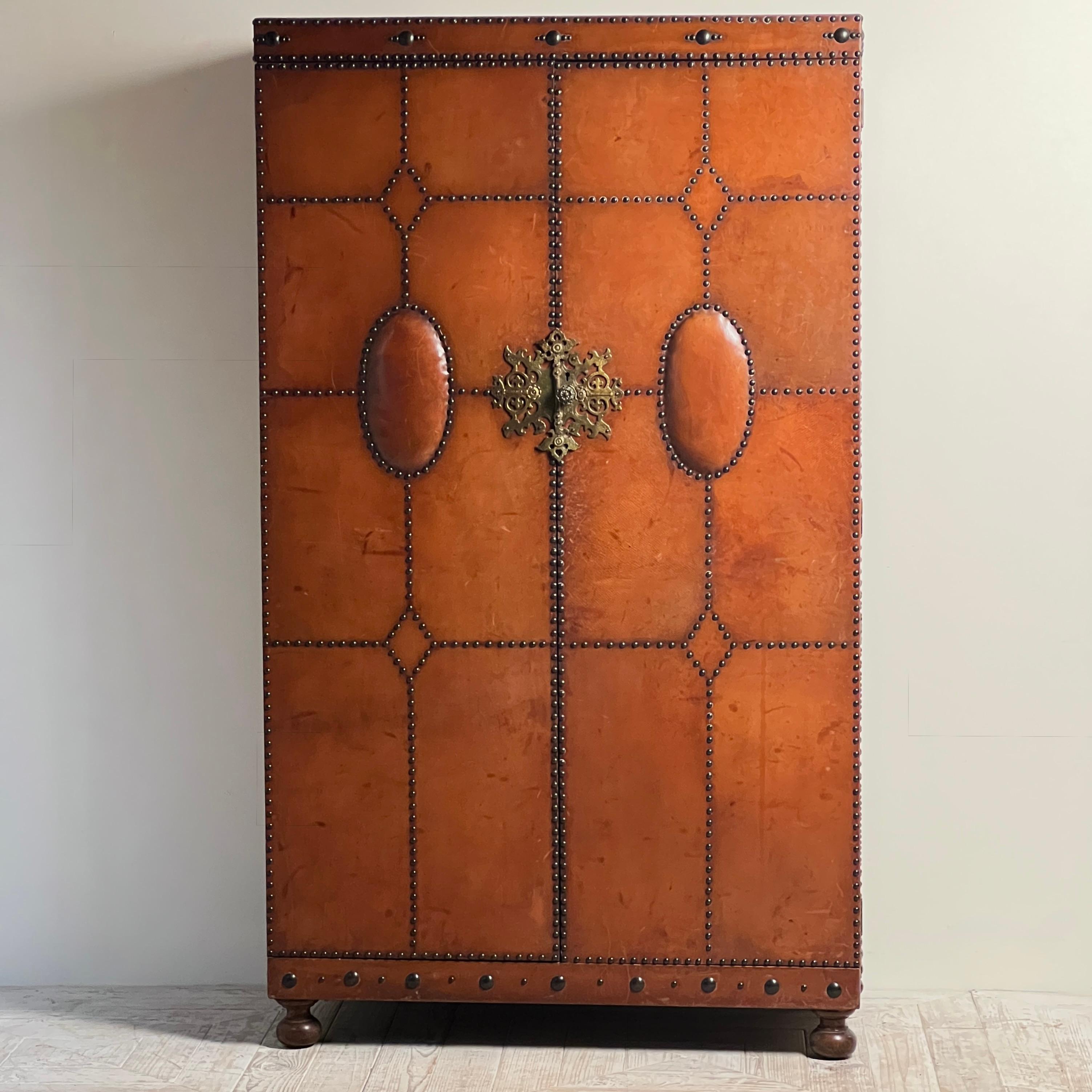 A Handsome 1920s–30s Spanish Leather-Clad Wardrobe with Stud Detailing

A superb Spanish wardrobe dating from the 1920s–30s, beautifully clad in warm cognac leather and finished with an impressive pattern of close-set brass studs. The piece has