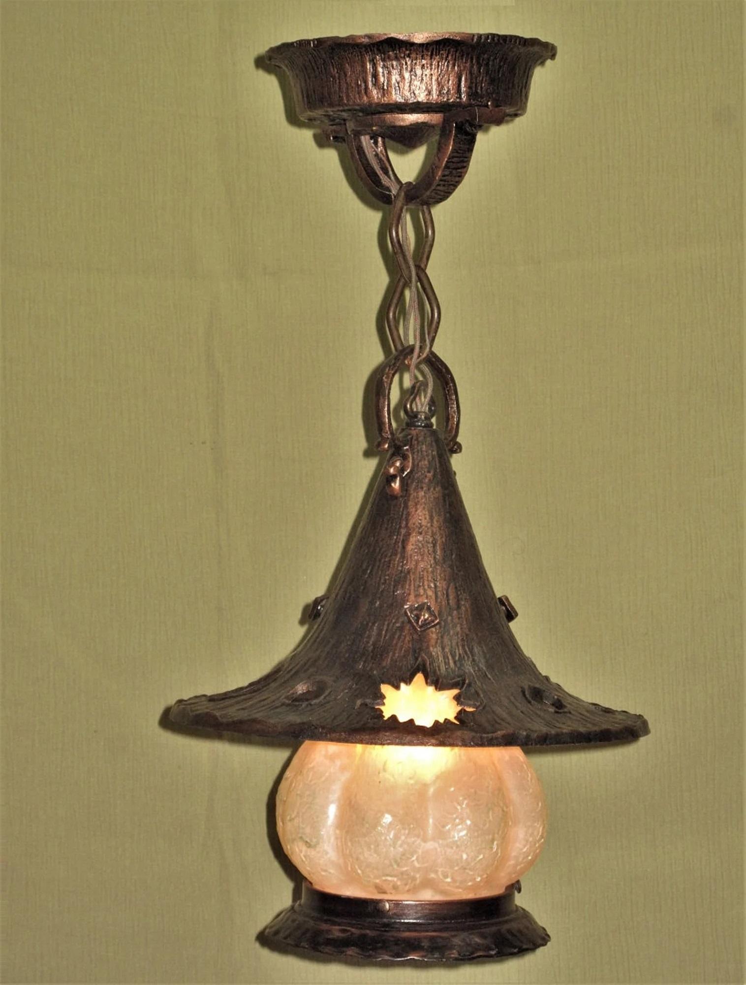 The best example of a Storybook style porch light we have ever had. Tall witches hat shade with the moon, star, sun, and planet cut outs ring the flair of the hat, covering a squatty milk glass shade. The witches hat covering, the bottom skirt on