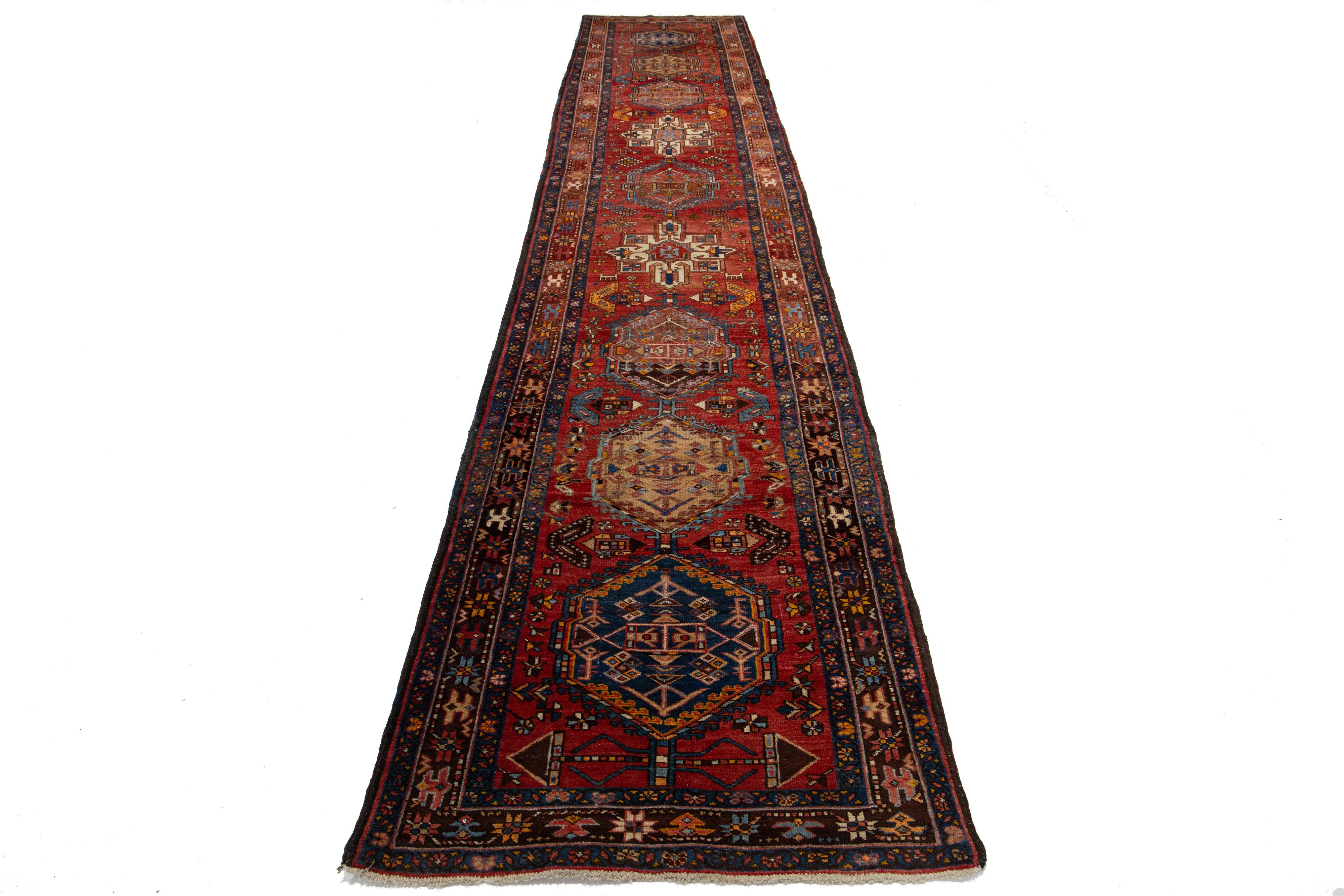 Questo bellissimo tappeto persiano in lana Heriz Handmade del XX secolo ha un campo rosso con accenti multicolori in tutto il disegno.

Questo tappeto misura 3'5'' x 17'9''.


