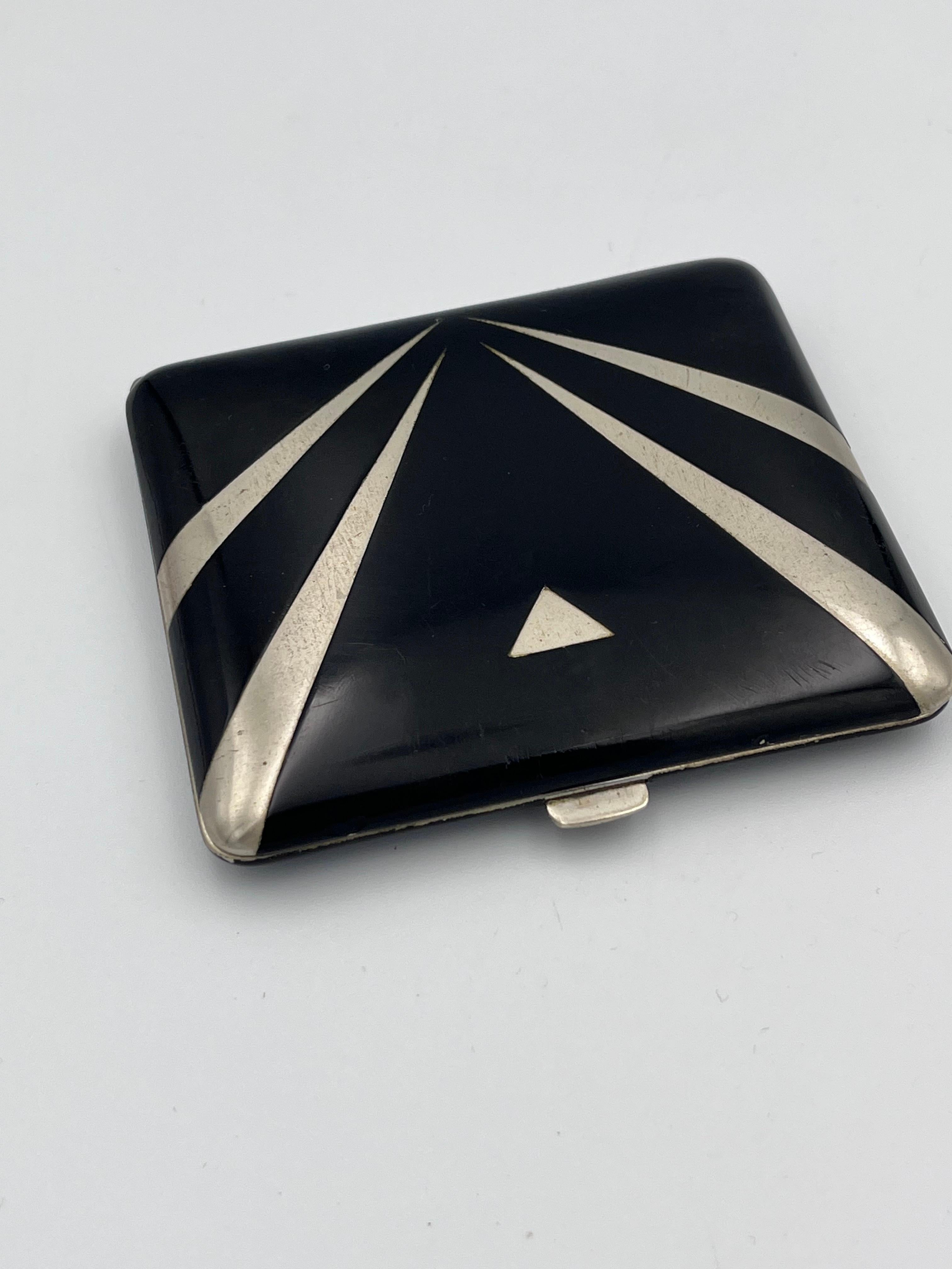Esta pitillera Alpacca Art Decó de 1920, con esmalte negro, es un ejemplo destacado del diseño alemán de principios del siglo XX, fabricada con la aleación históricamente conocida como 