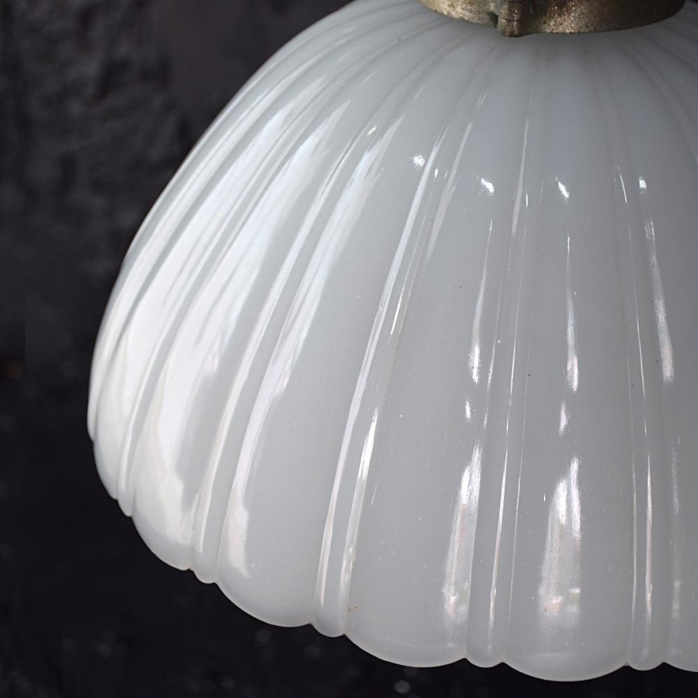 Large Jefferson light

A lovely original 1920s classic Jefferson Light shade made from ridged glass with a frilled rim still attached to its original untouched gallery. The gallery has an unusual lock and unlock bolt mechanism, allowing the light