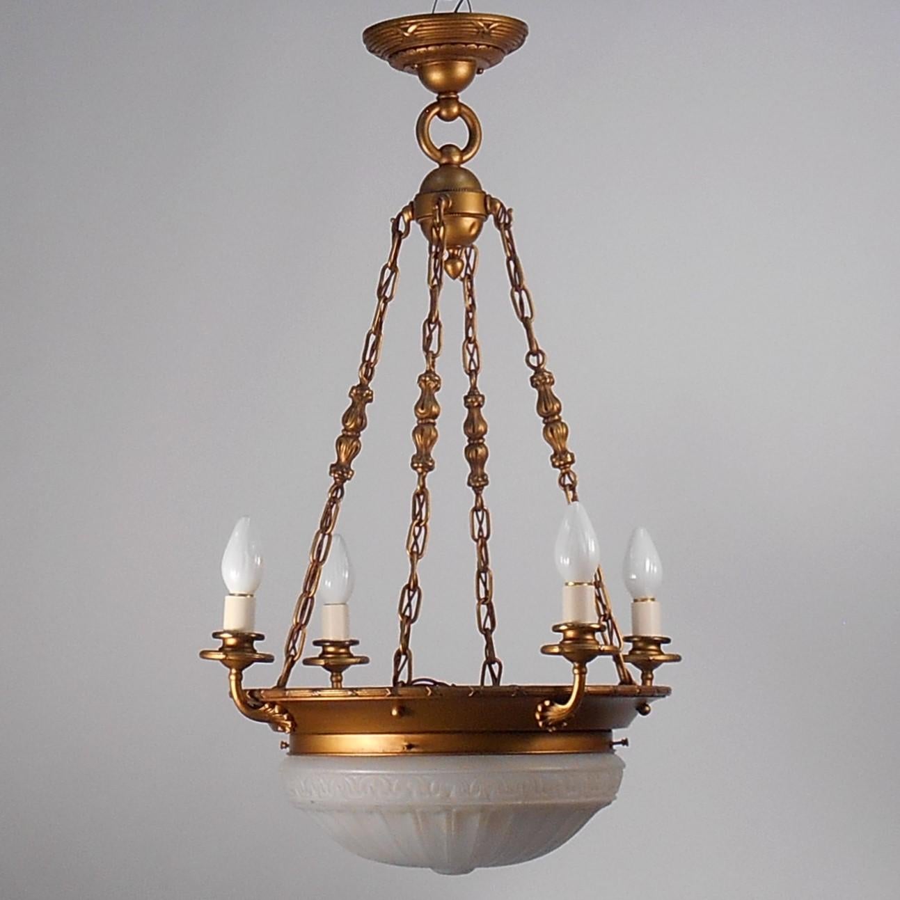 A beautiful example of 1920's fixture featuring a frosted embossed glass shade and 4 medium base candle sockets. The metal reed and ribbon motif repeat from the Boesche to the top rim of the metal bowl and ceiling canopy. Each of the four candle