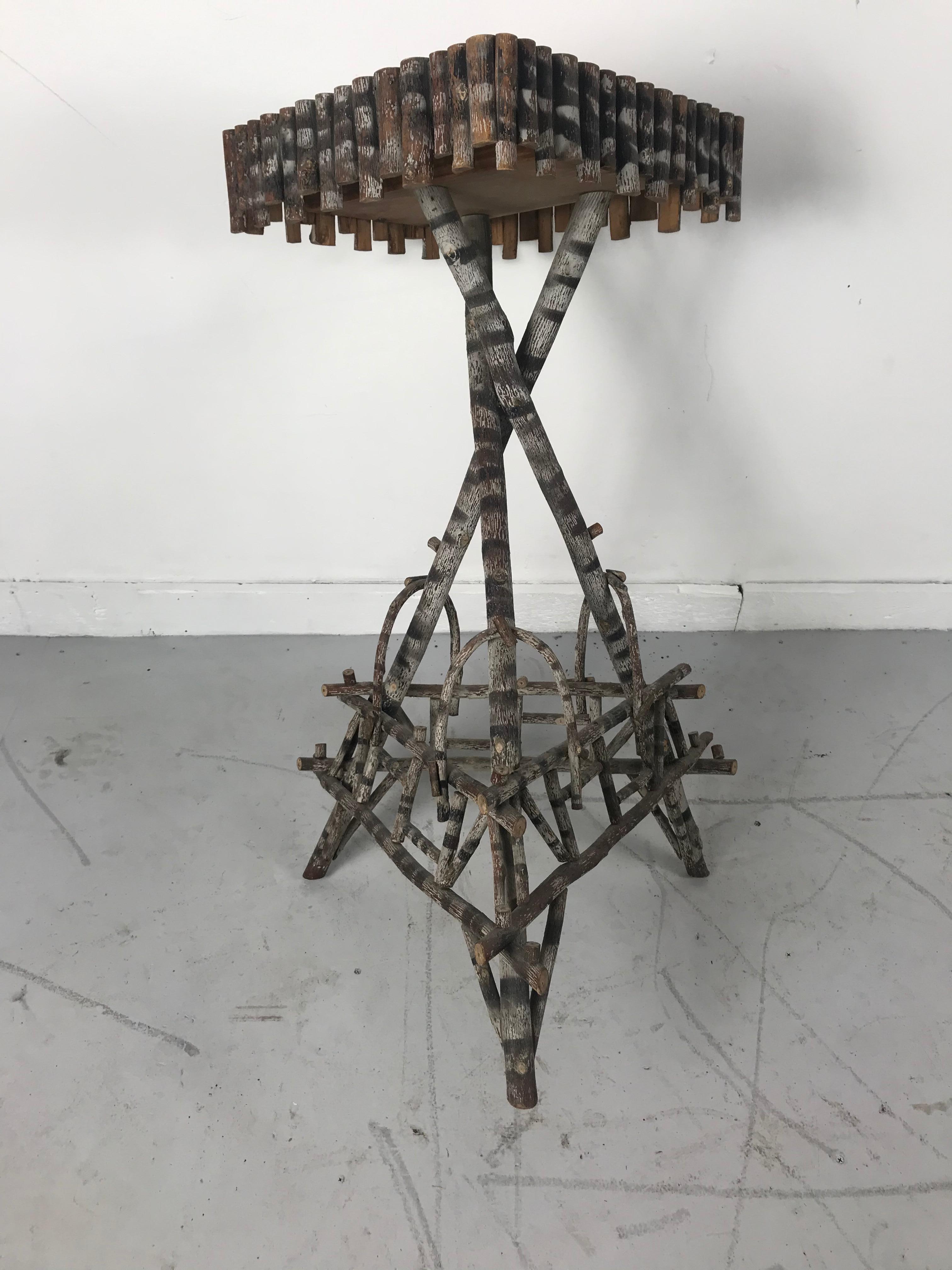 Rustic American Adirondack (1920s) end table with a twig and root base
supporting an oak square top.