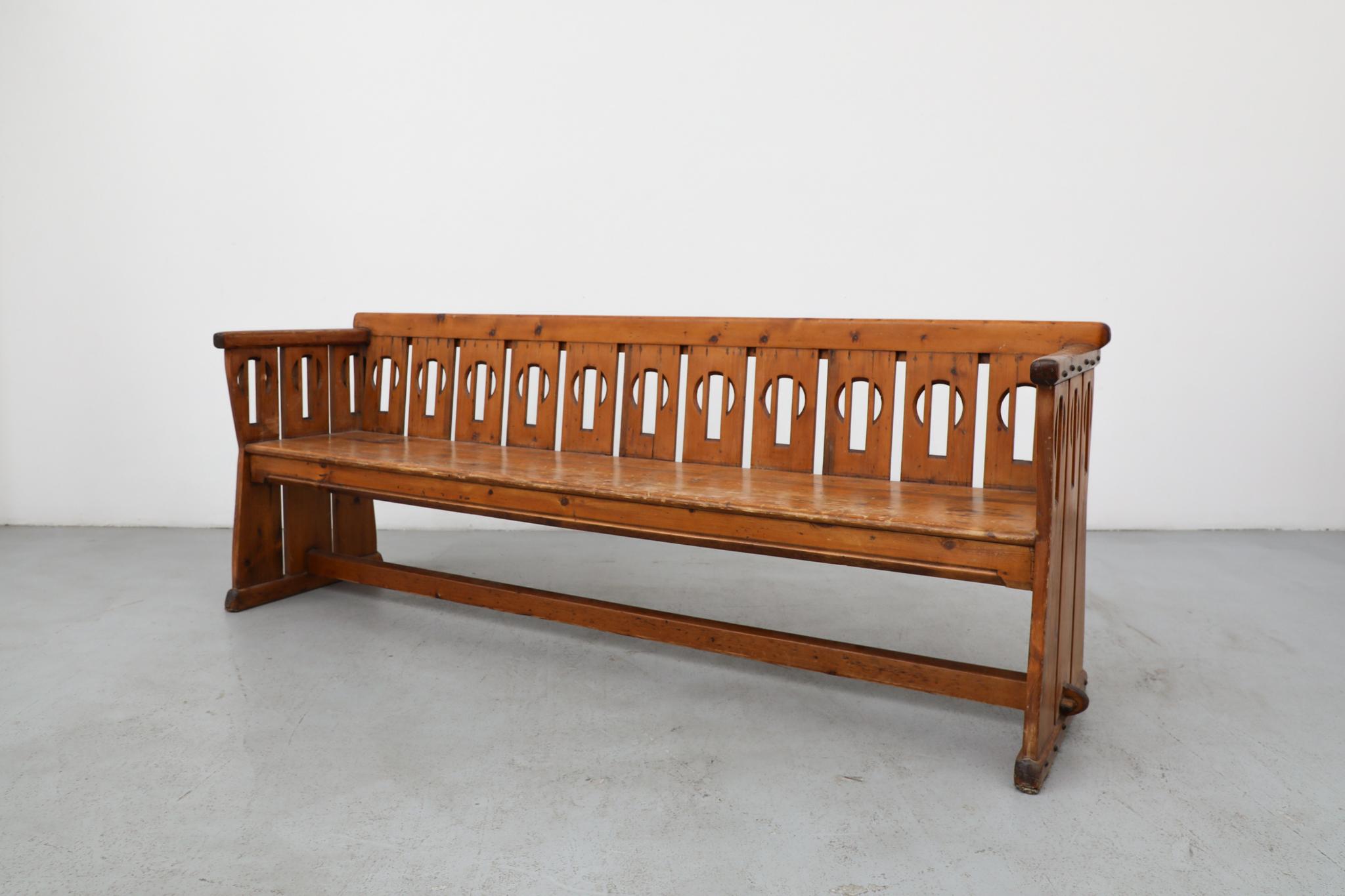 Importante banquette ou banc d'église en bois de l'école d'Amsterdam des années 1920, avec un dossier sculptural et décoratif, reflétant la phase audacieuse et expressionniste de l'Art déco hollandais. Cette pièce remarquable est présentée dans son