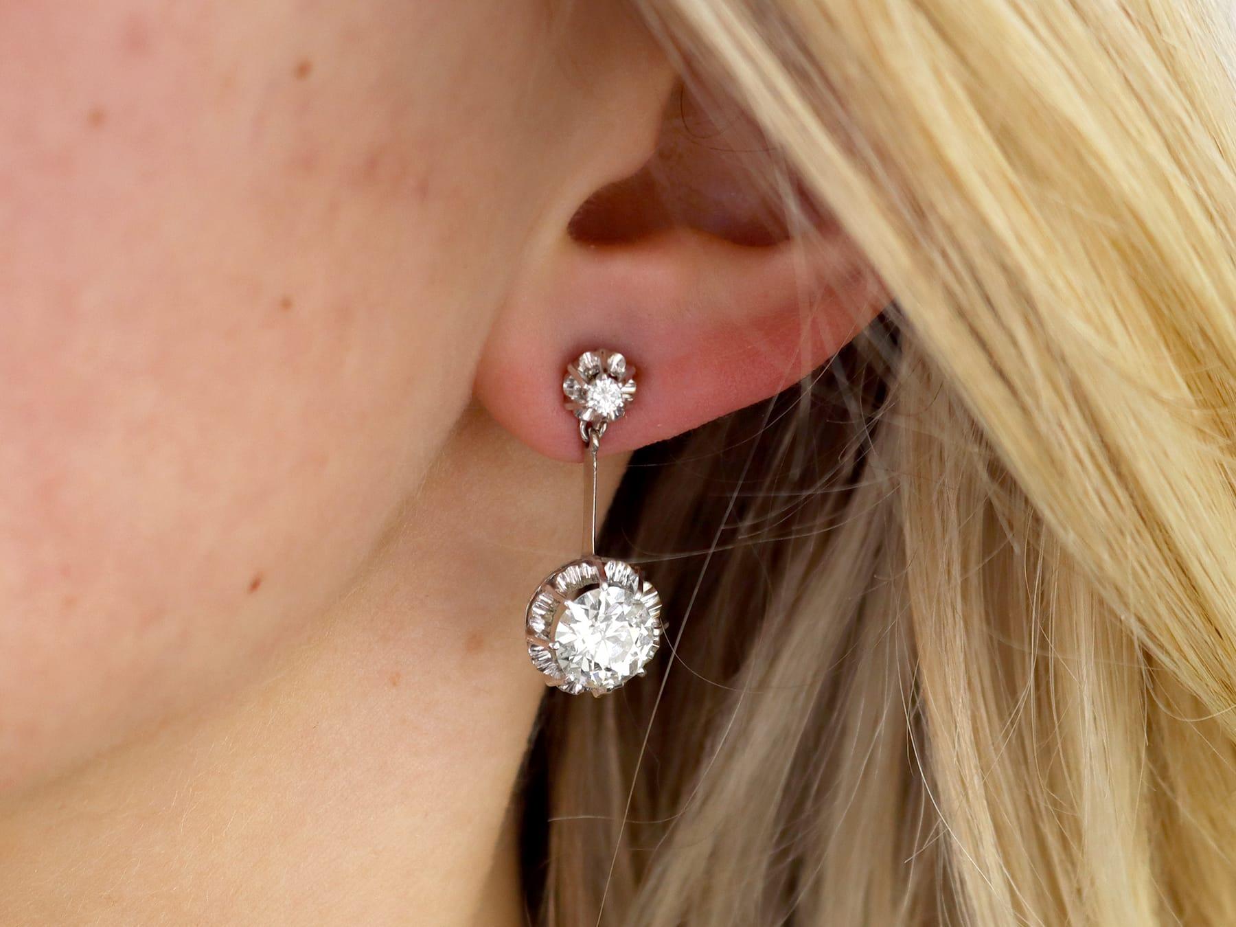 A stunning, fine and impressive pair of antique 4.70 carat diamond and platinum drop earrings; part of our diverse diamond earring collections.

These stunning antique 1920s earrings have been crafted in platinum.

These earrings are embellished