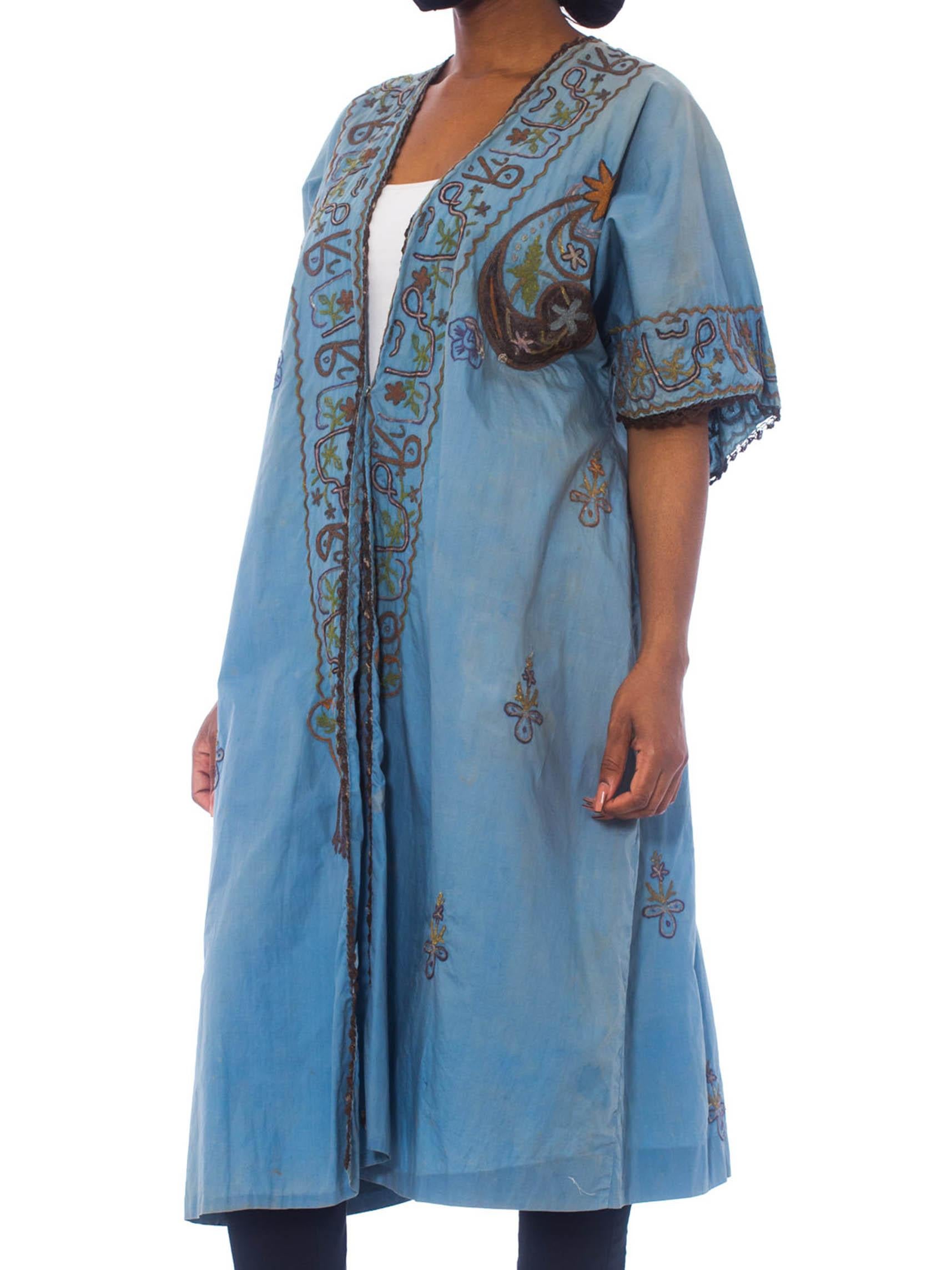 This piece is over 100 years old and bears a patina of its worldly travels across a century of time. 1920S Dusty Blue Silk/Cotton Blend Antique Hand Dyed Short Sleeve Mesopotamian Kimono Kaftan With Metallic Embroidery 