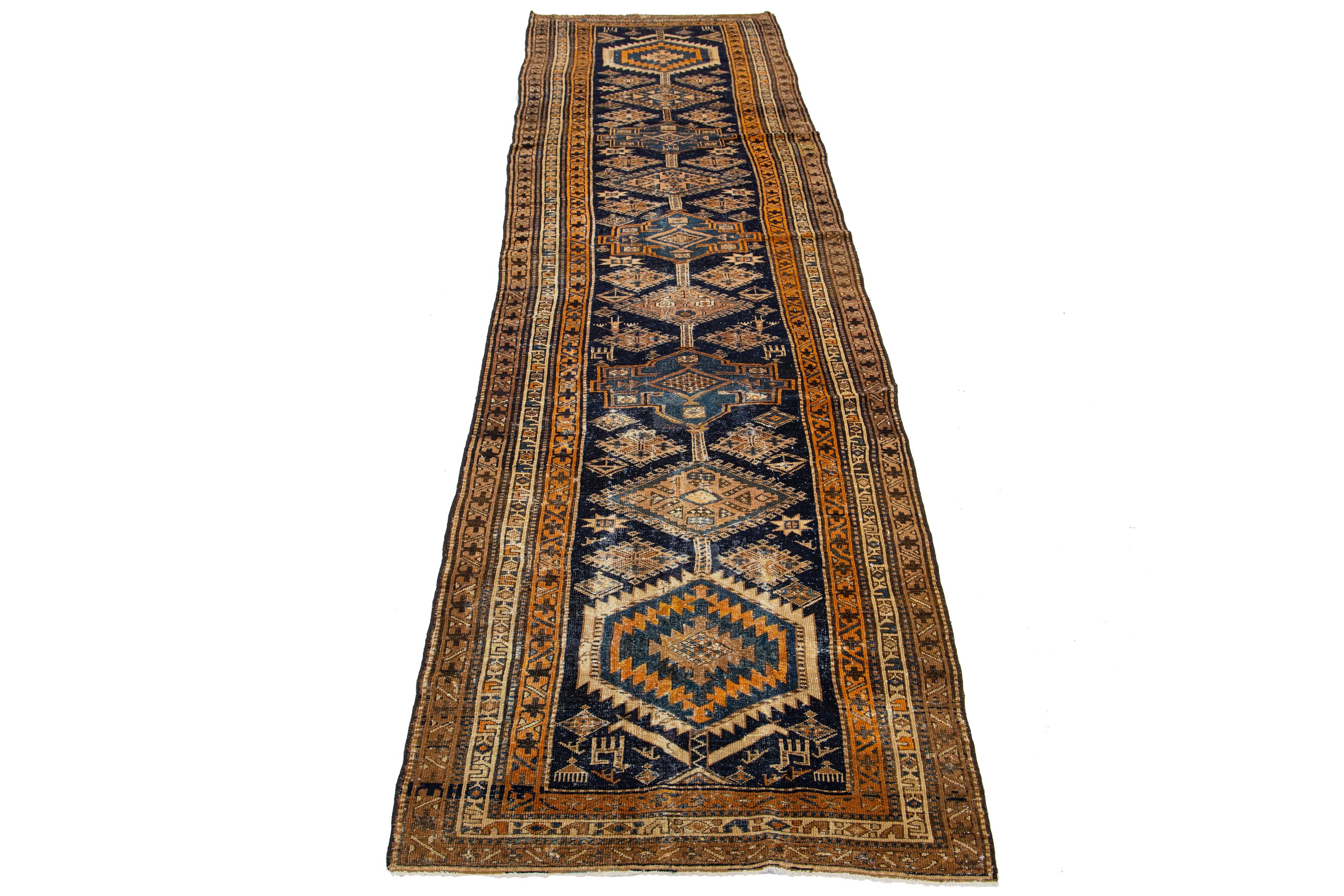 Beautiful 20th-century Heriz hand-knotted wool runner with a dark blue color field. This Piece has multicolor accents in a gorgeous tribal design.

This rug measures 3'5