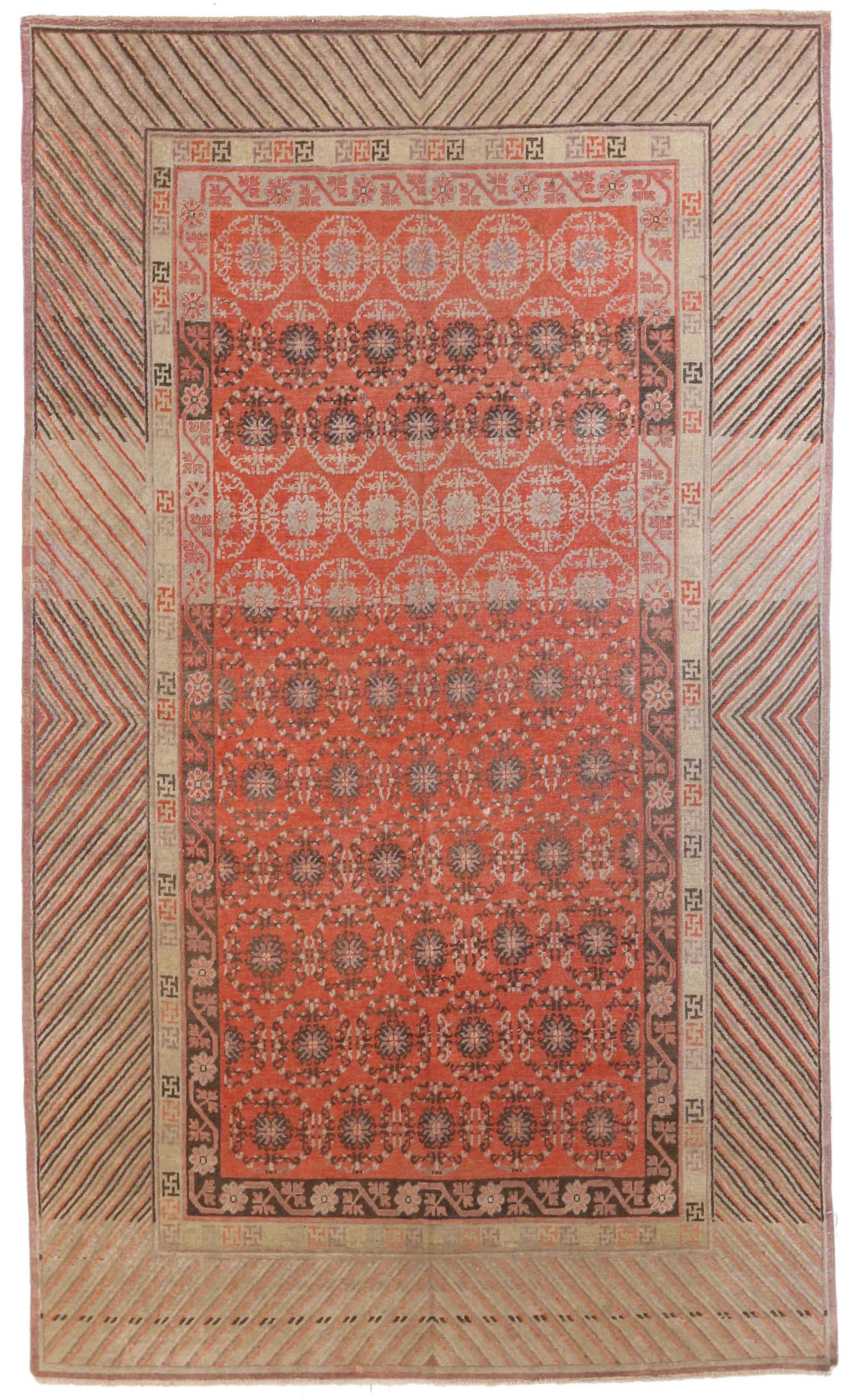 Antique Central Asian rug is woven by hand using high-quality wool and the best natural dyes in the region. It features a lively combination of geometric and nature-inspired design patterns favored by Khotan weavers. This piece has a vibrant color