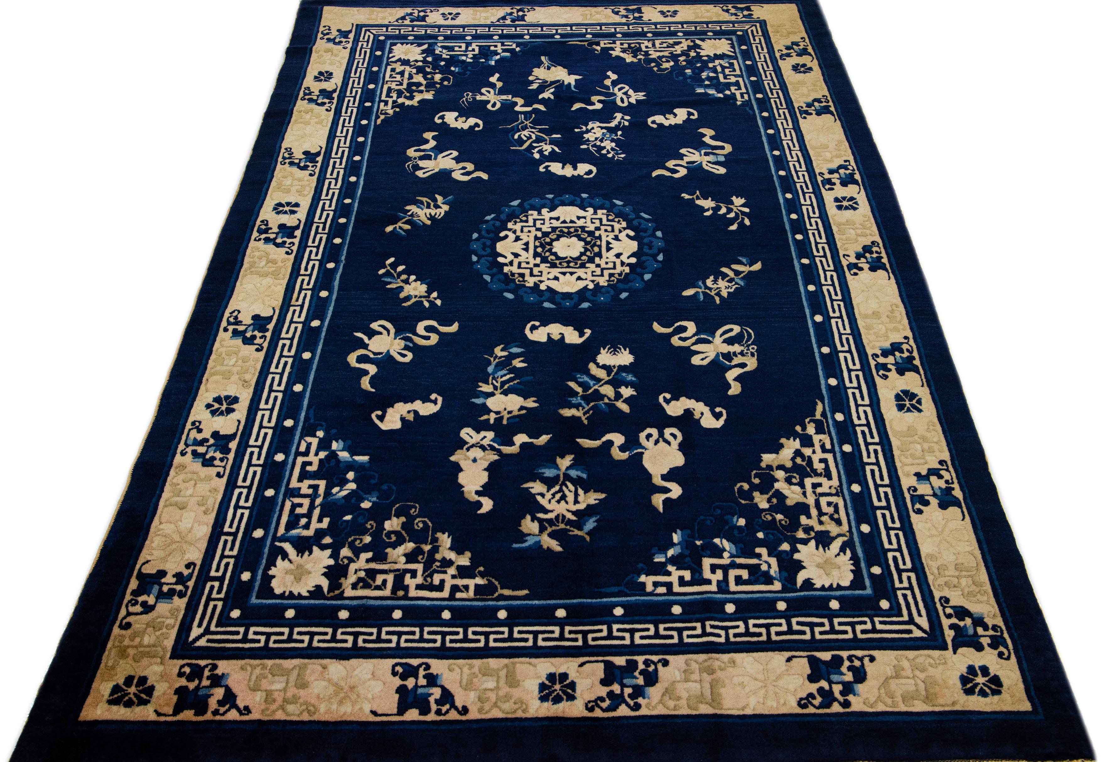 This luxurious antique Peking Chinese hand knotted wool rug features a navy blue field adorned with a designed frame and golden accents in a stunning all-over Chinese floral motif.

This rug measures: 5'1