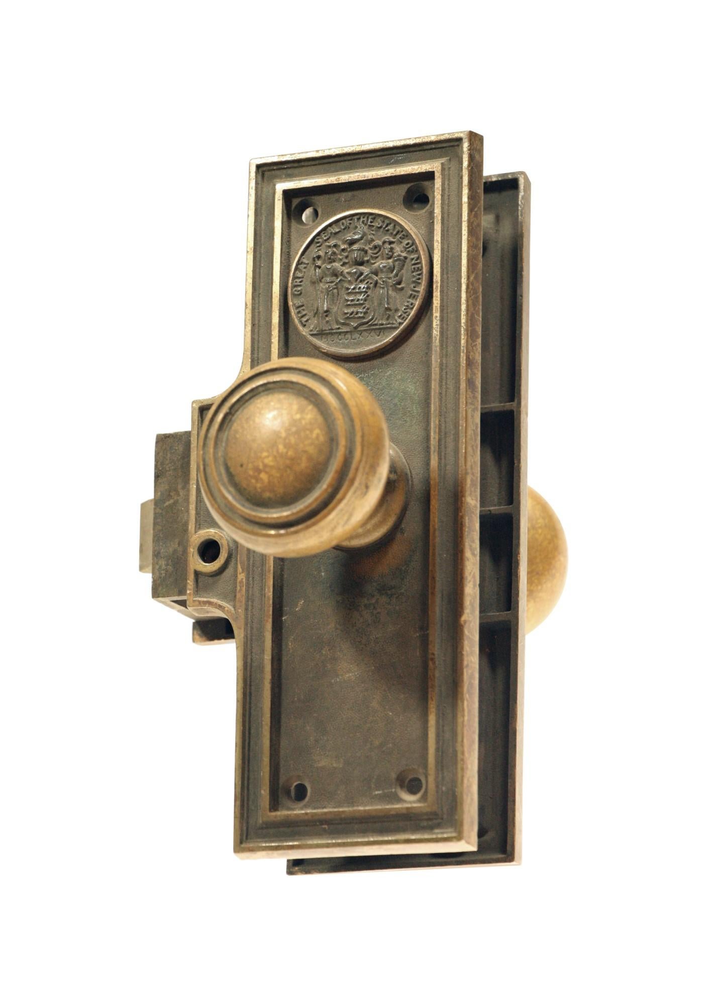 1920s Corbin unit lock set with an emblematic back plate that reads 'The great State of New Jersey, XOCCLXXVI' and a concentric style knob. Set includes a pair of doorknobs, two back plates, and an attached lock. Collectable. Unit locks were meant
