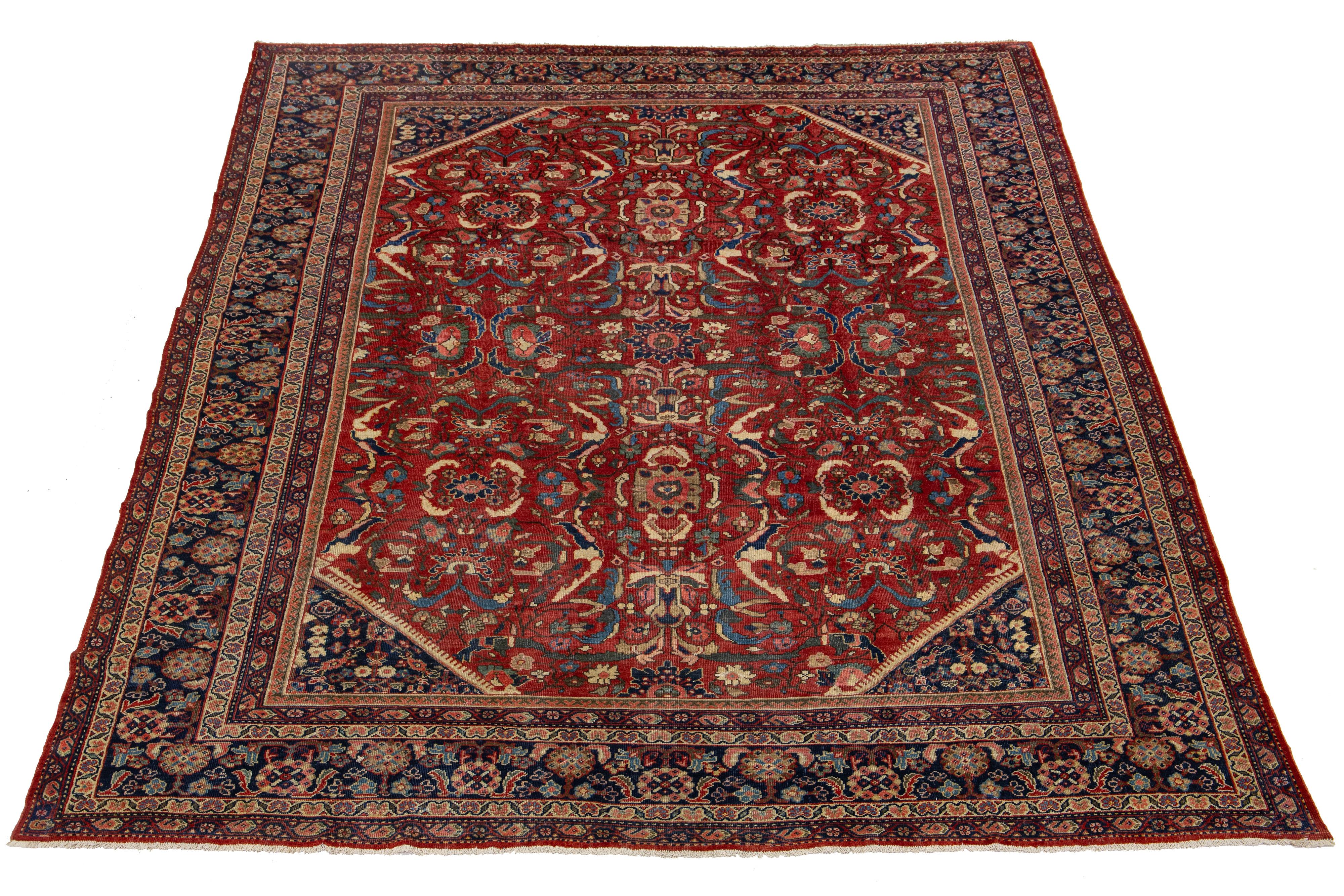 Tapis en laine persan Mahal du XIXe siècle, fait à la main, avec champ rouge et motifs floraux multicolores. 

Ce tapis mesure 10' x 13'6