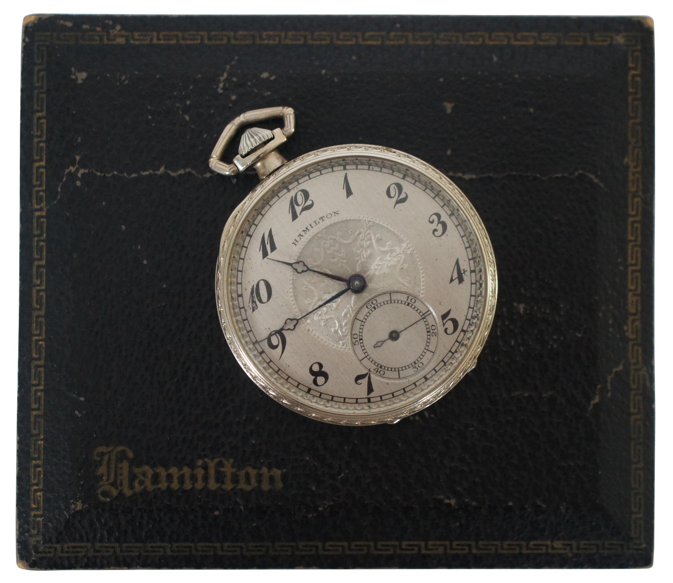 Antique 1920’s 14K white gold filled mechanical railroad pocket watch by Hamilton Watch Company of Lancaster, PA, featuring an art deco foliate design around the sides and an embossed medallion on the face; case marked with Fahys caduceus logo and