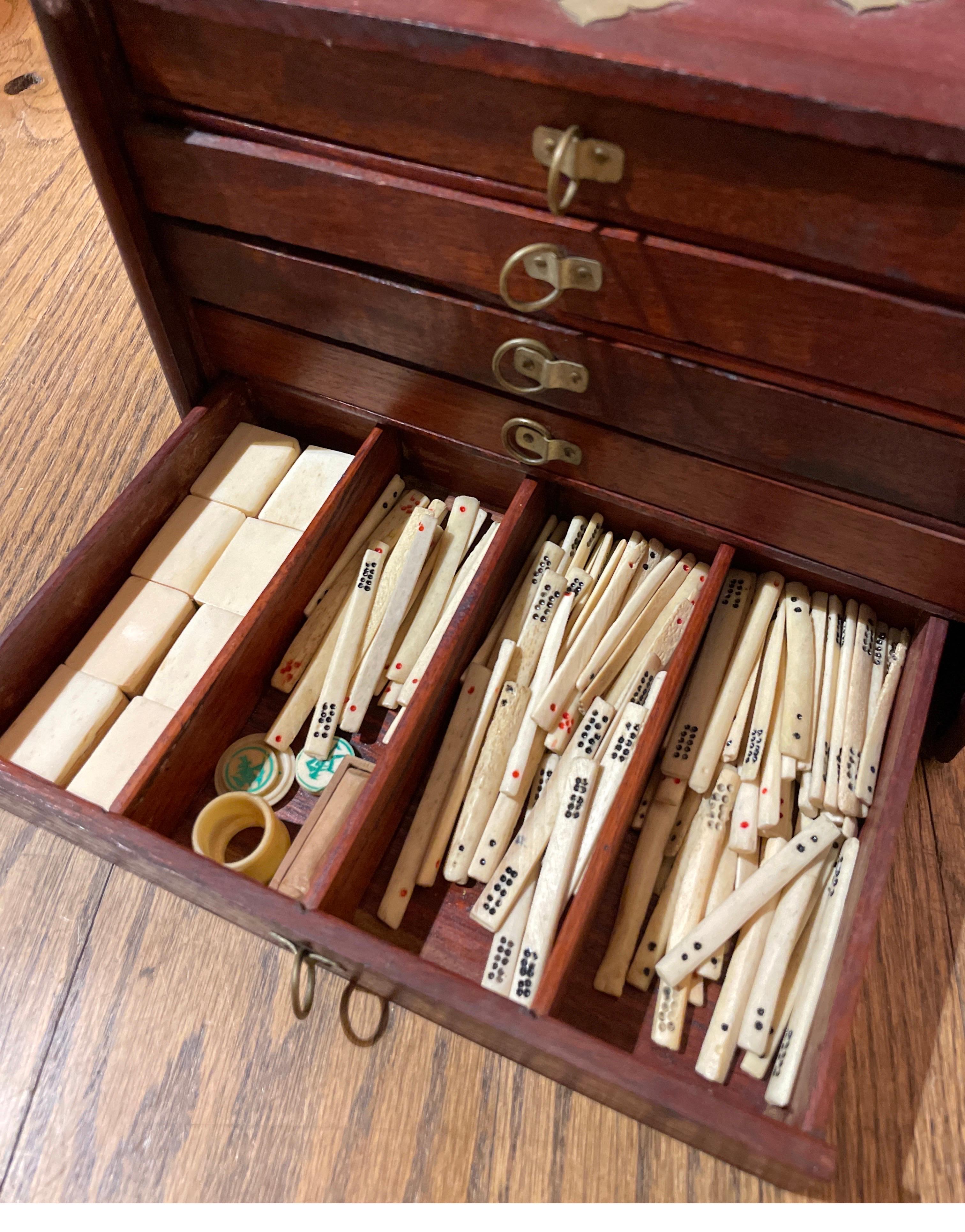 Antiguo Juego de Mahjong Chino de los Años 20 Baldosas de Bambú y Hueso de 3x2x1cm 
Las Baldosas Especiales son Flores, Talladas y Pintadas 
La caja incluye los dados de los palos de apuestas con caja y los discos de dirección 
Caja de madera teñida