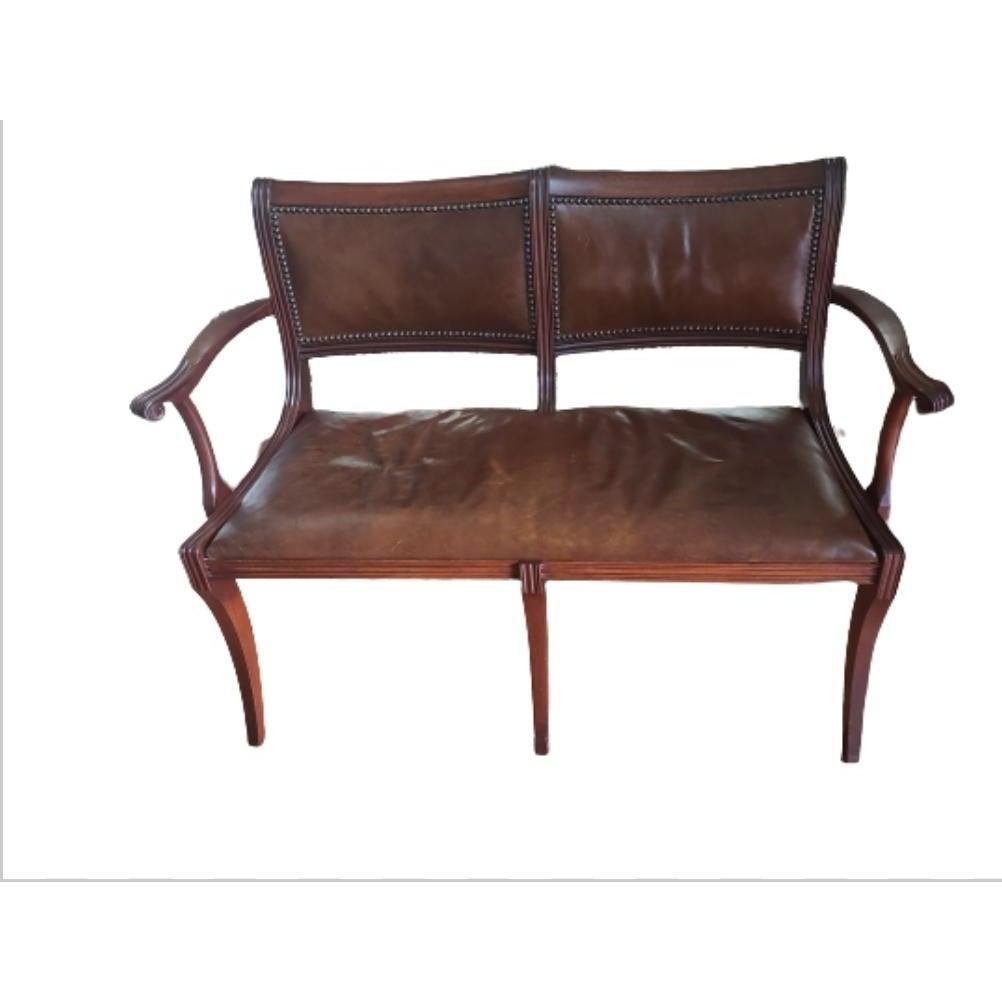 Rare mahogany and top grain leather settee by Colonial Manufacturing. Antique from the 1920s. Very good Antique condition with minor nick on Mahogany, no cracks on Leather seats, but some discoloration. Leather seats and back. Measures 44