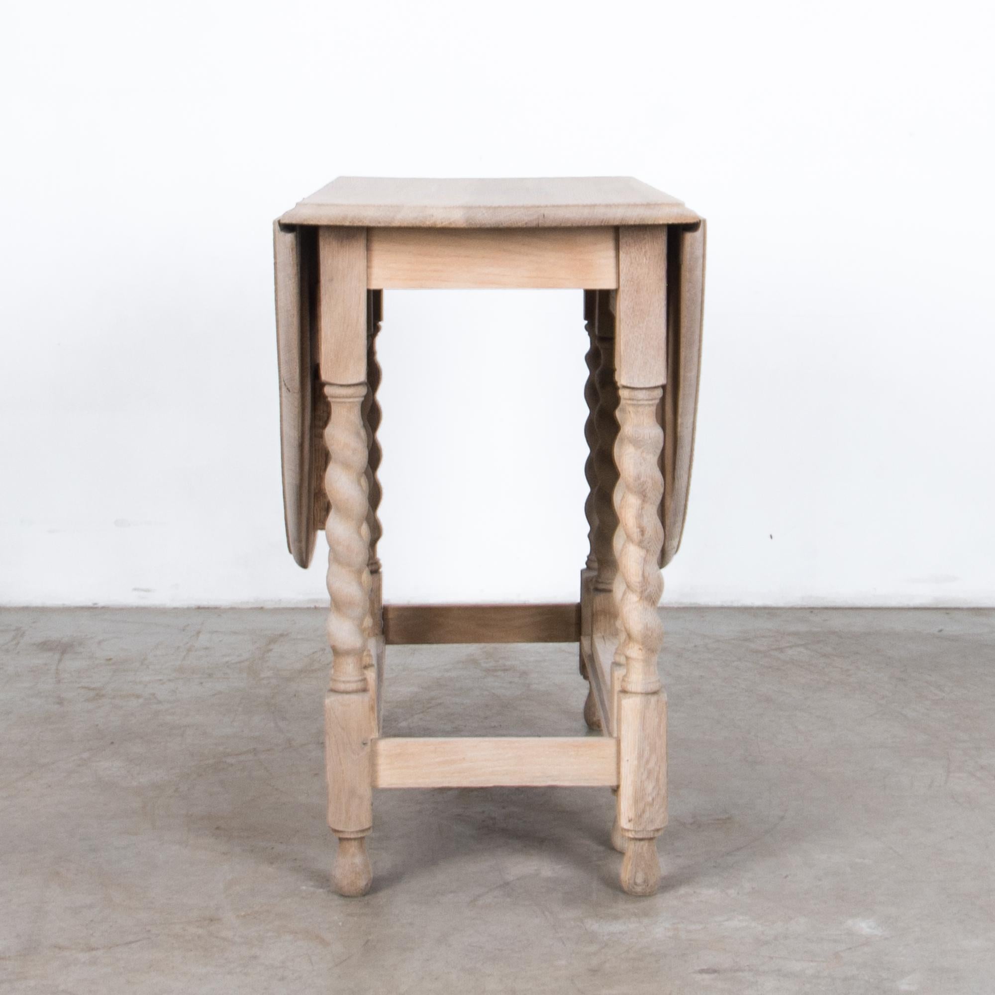 A folding gate leg table from the United Kingdom, circa 1920. The folding gate leg makes this table versatile and practical while retaining stability, and style. Carved details and turned table legs give a classical inflection, “twisted barley