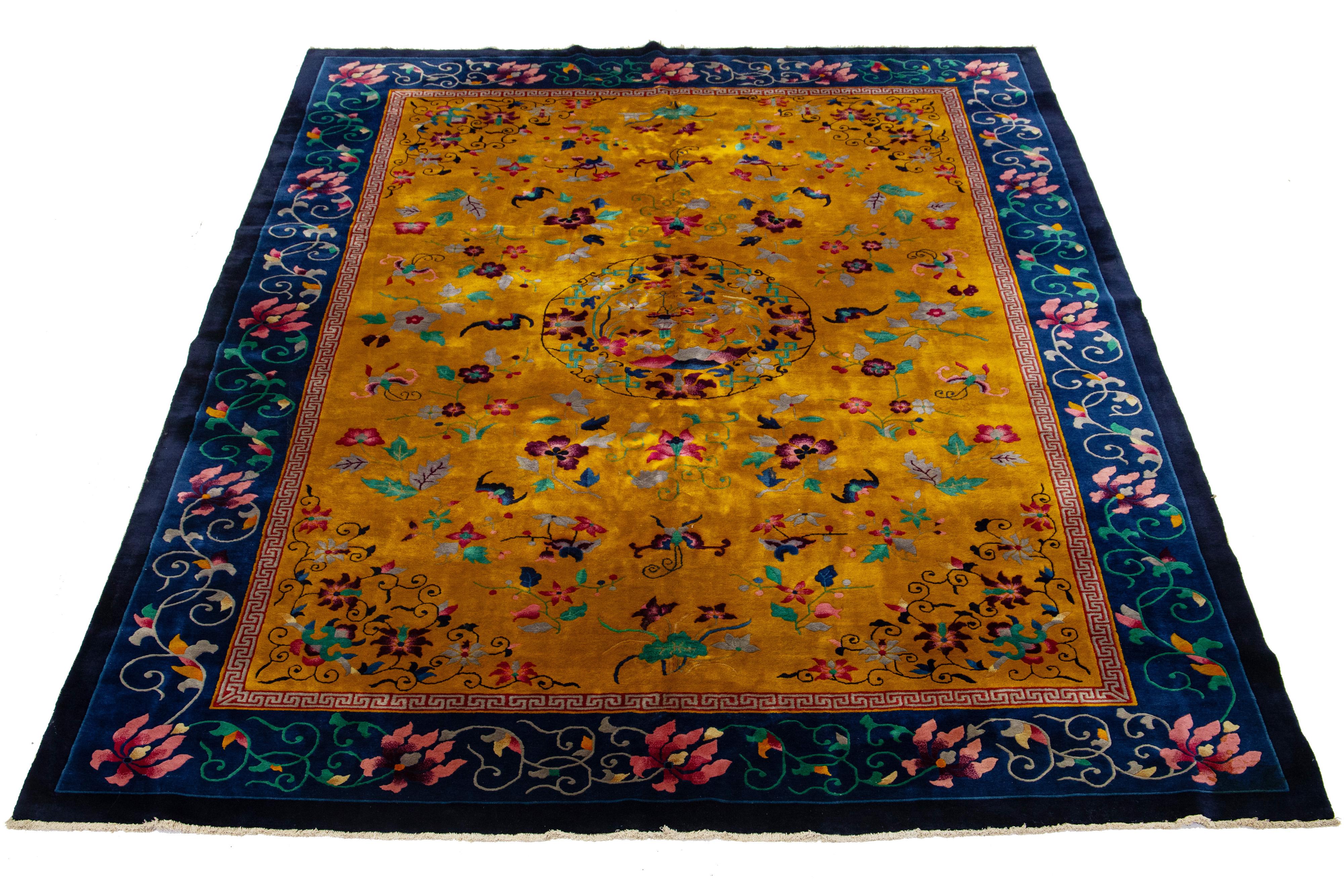 This luxurious antique Peking Chinese hand-knotted wool rug showcases a goldenrod color field embellished with a navy blue designed frame and multicolor accents, all arranged in a breathtaking all-over Chinese floral motif.

This rug measures 9'10