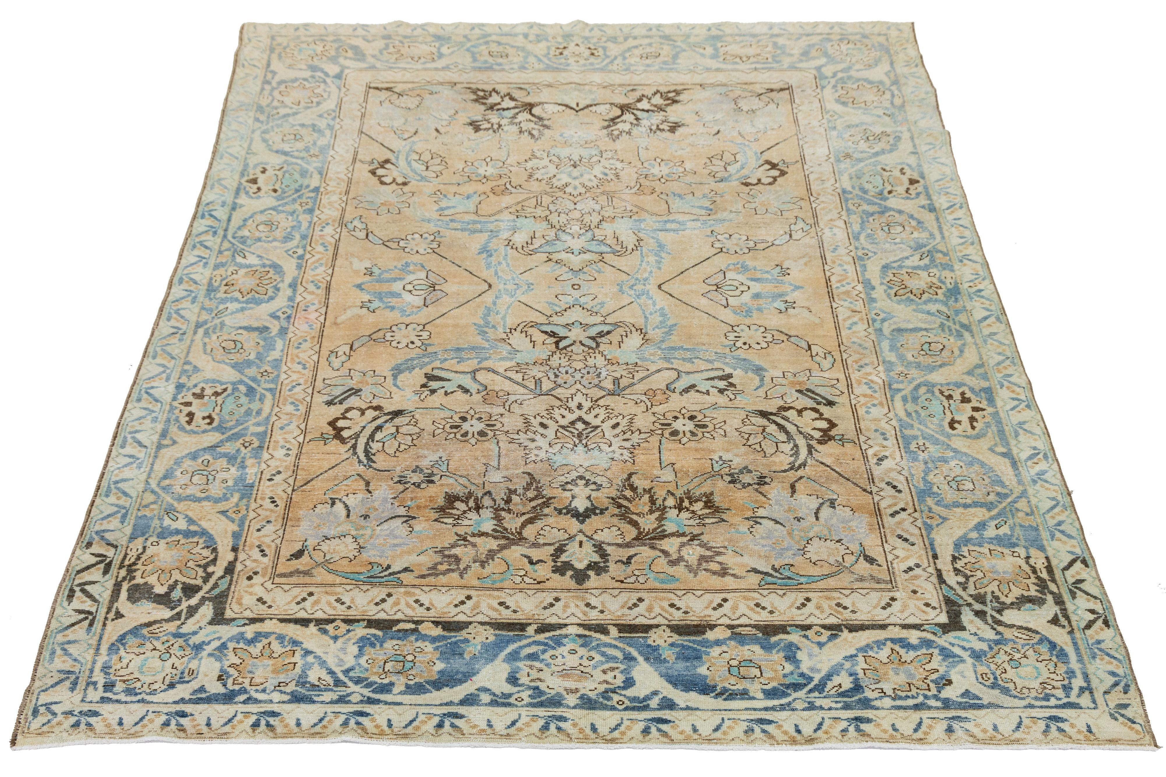 Découvrez l'élégance de ce tapis ancien en laine nouée à la main de Malayer, qui présente un riche fond beige orné d'un superbe motif floral, magnifiquement rehaussé par des touches de bleu, de gris et de brun.

Ce tapis mesure 7' x 9'3