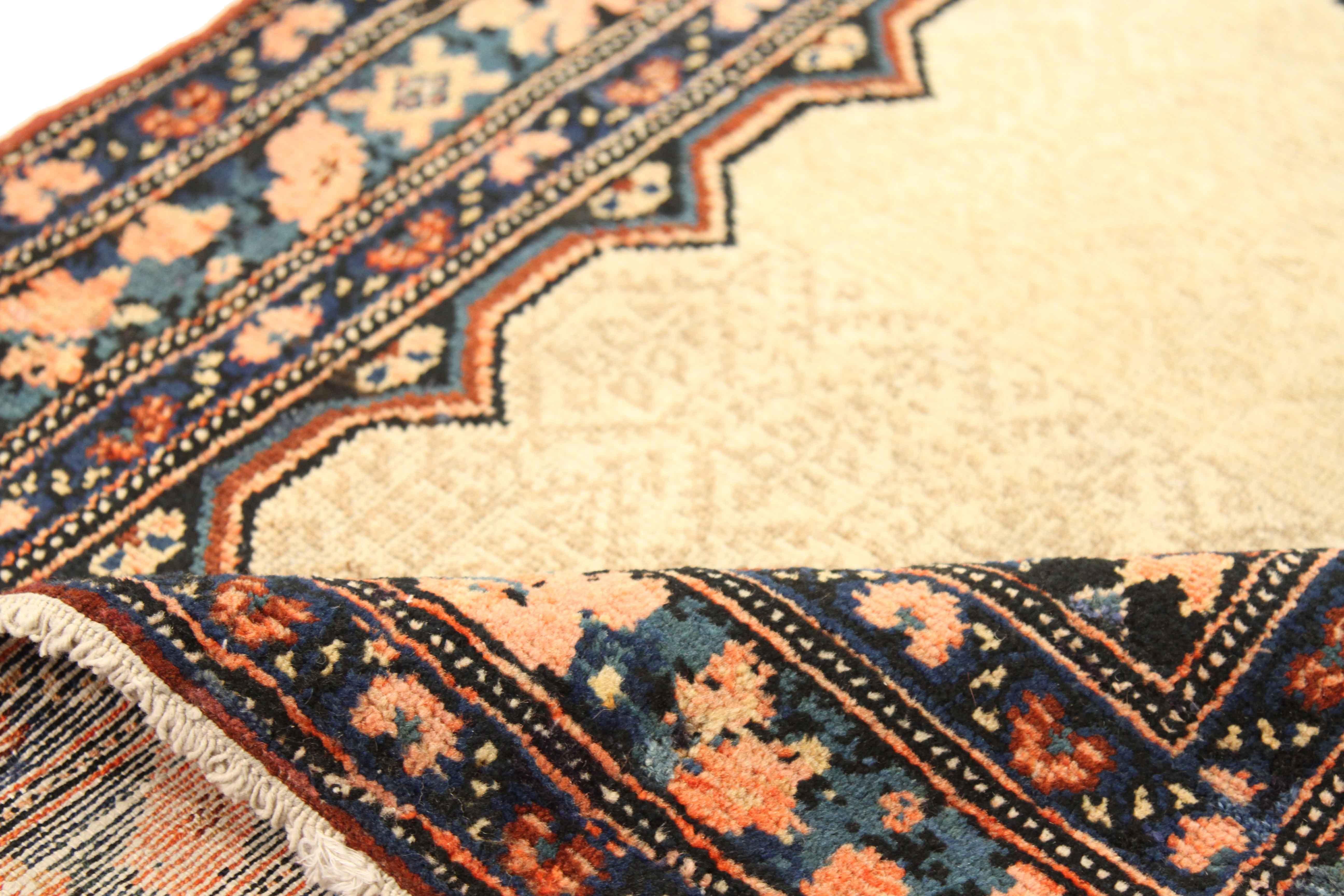 Créé avec de la laine filée à la main de la plus haute qualité, ce tapis persan ancien présente un motif tribal spectaculaire attribué aux fins tisserands de Malayer. Pour cette pièce, un mélange royal d'ivoire, de rouge, de noir et de marine a été