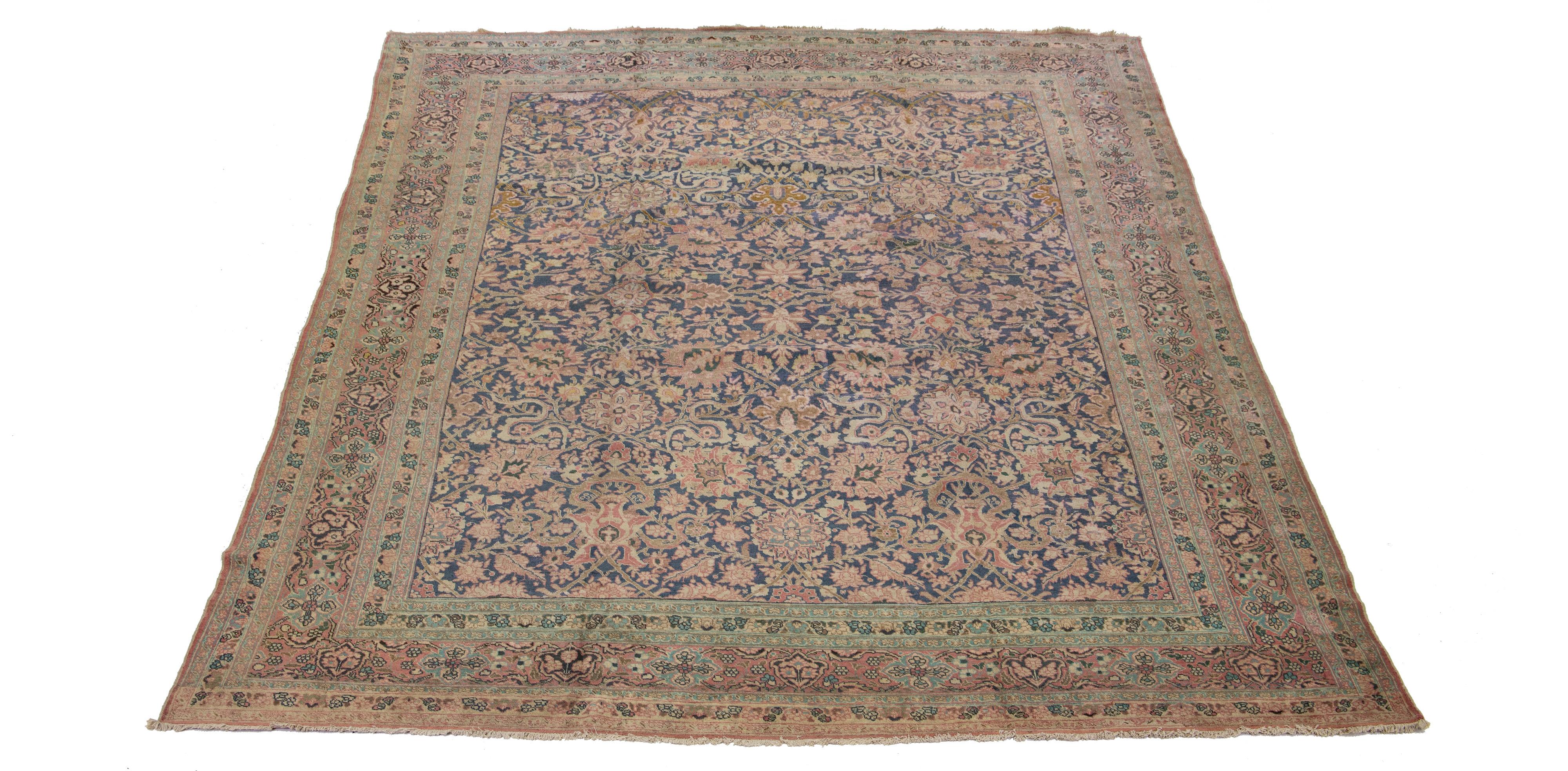 The handcrafted Persian Tabriz wool rug from the 1920s features a stunning, traditional rosette design. A bold teal and pink coloring accentuate the pattern, uniquely contrasting the rug's blue background.

This rug measures 10'10