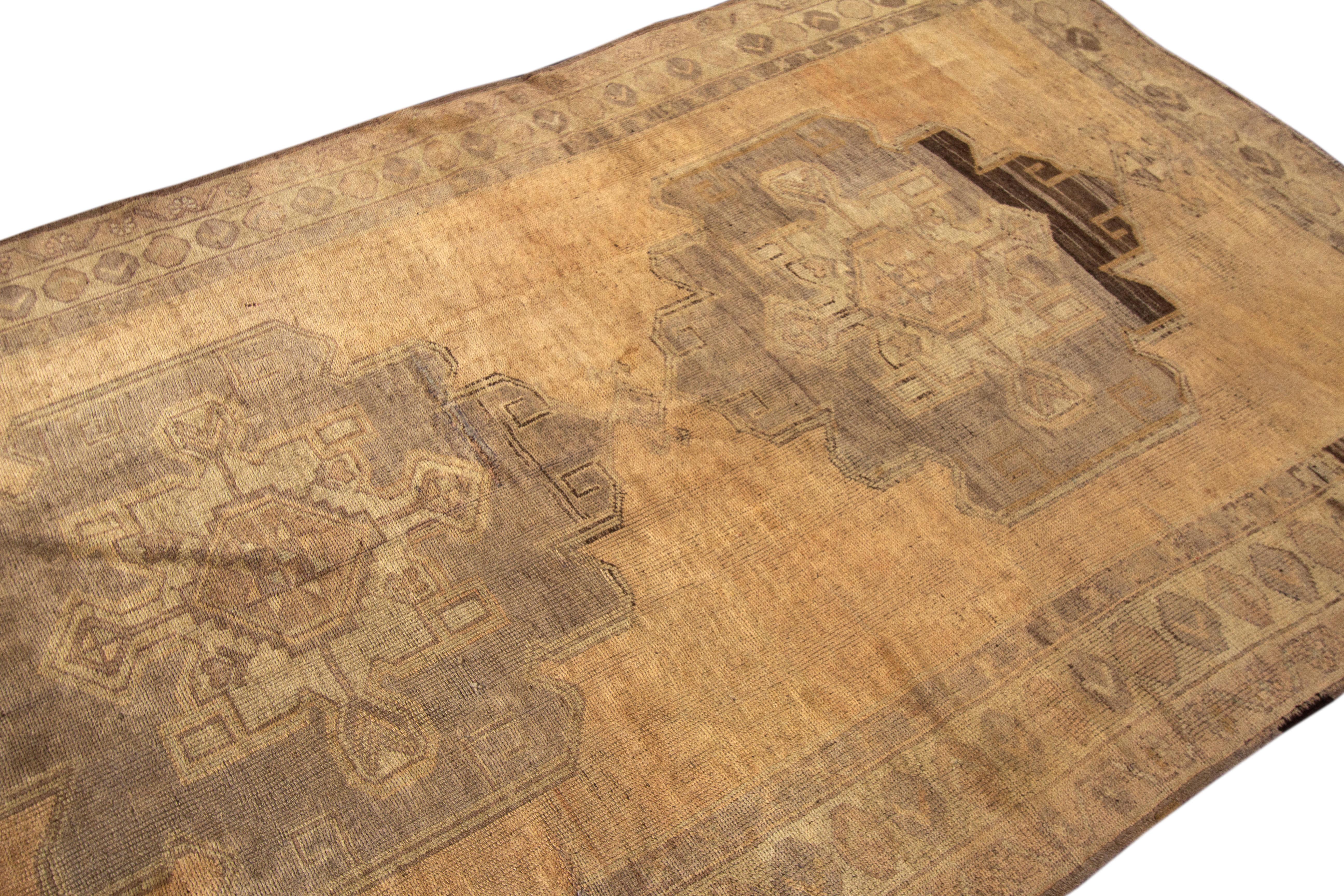 Beautiful Antique Turkish Khotan hand-knotted wool rug with a tan field. This Khotan has gray, brown, and blue accents in a gorgeous all-over medallion floral motif design.

This runner measures 5'2
