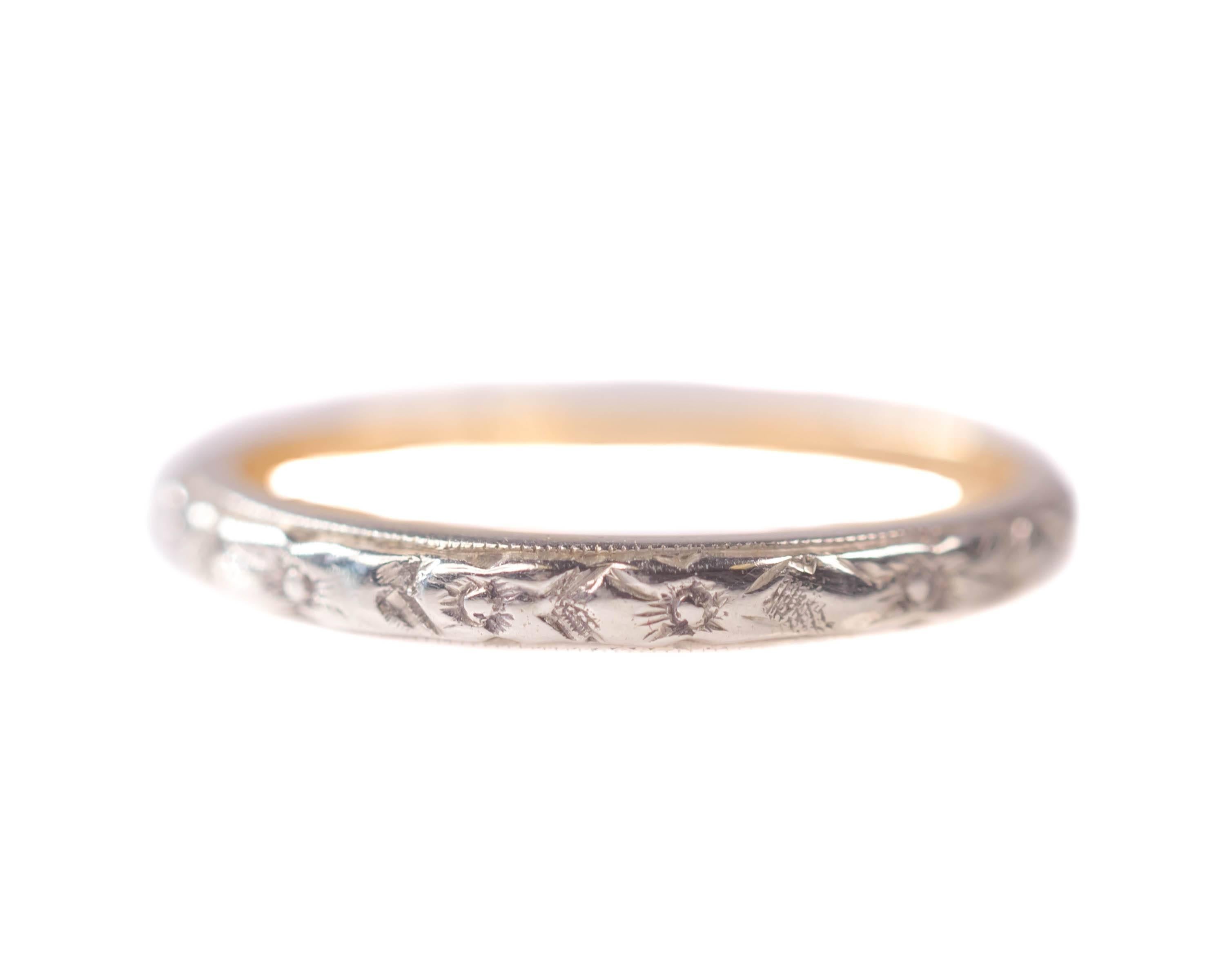 1920s Art Deco Floral Pattern Band - 18 Karat White Gold, Yellow Gold

Features an 18K White Gold outer shank and an 18K Yellow Gold inner shank. The face of the ring is etched with a delicate floral pattern. The upper and lower edges are