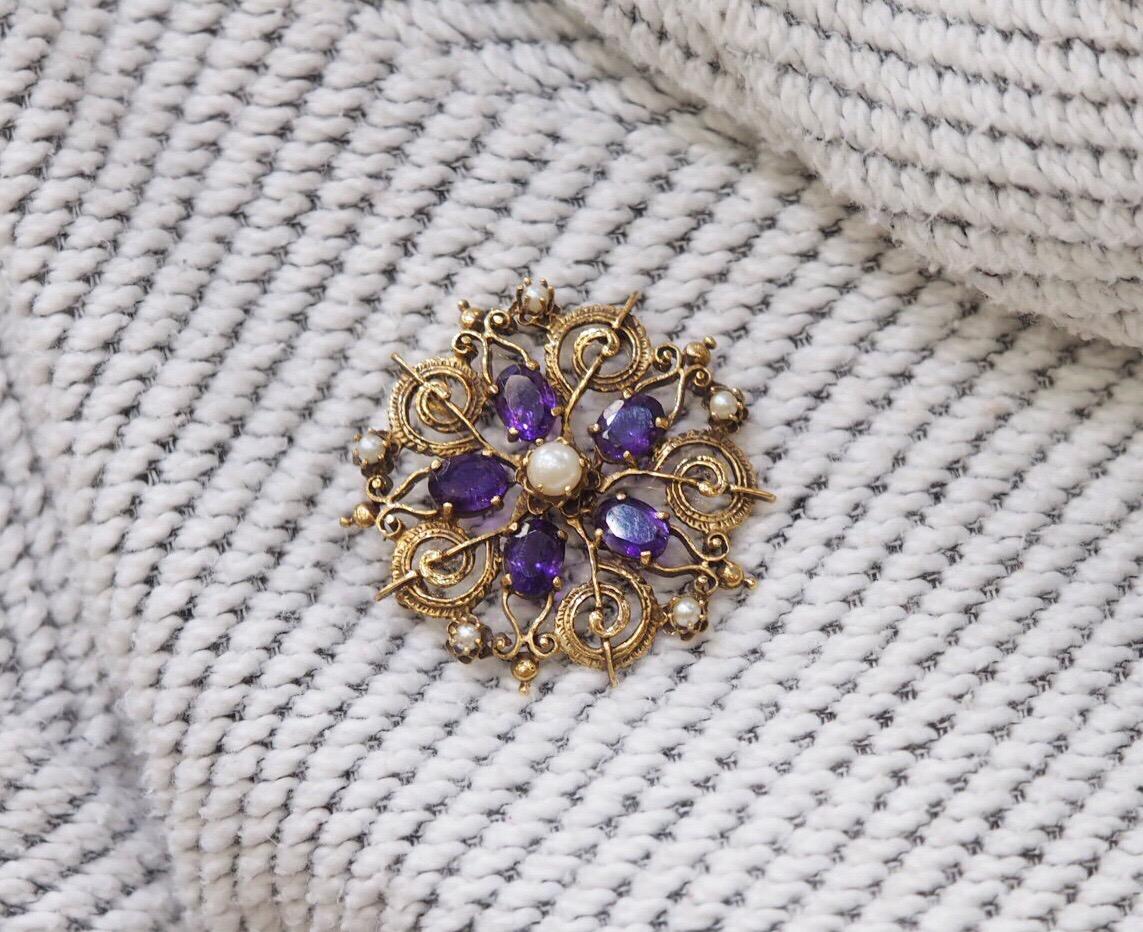 This 1920's Amethyst and Pearl Brooch Pendant is a spectacular piece in great condition for being 100 years old. It has four natural oval amethyst measuring 8 x 6mm. The pearl in the center measures 5.5mm and the five smaller pearls on the outside