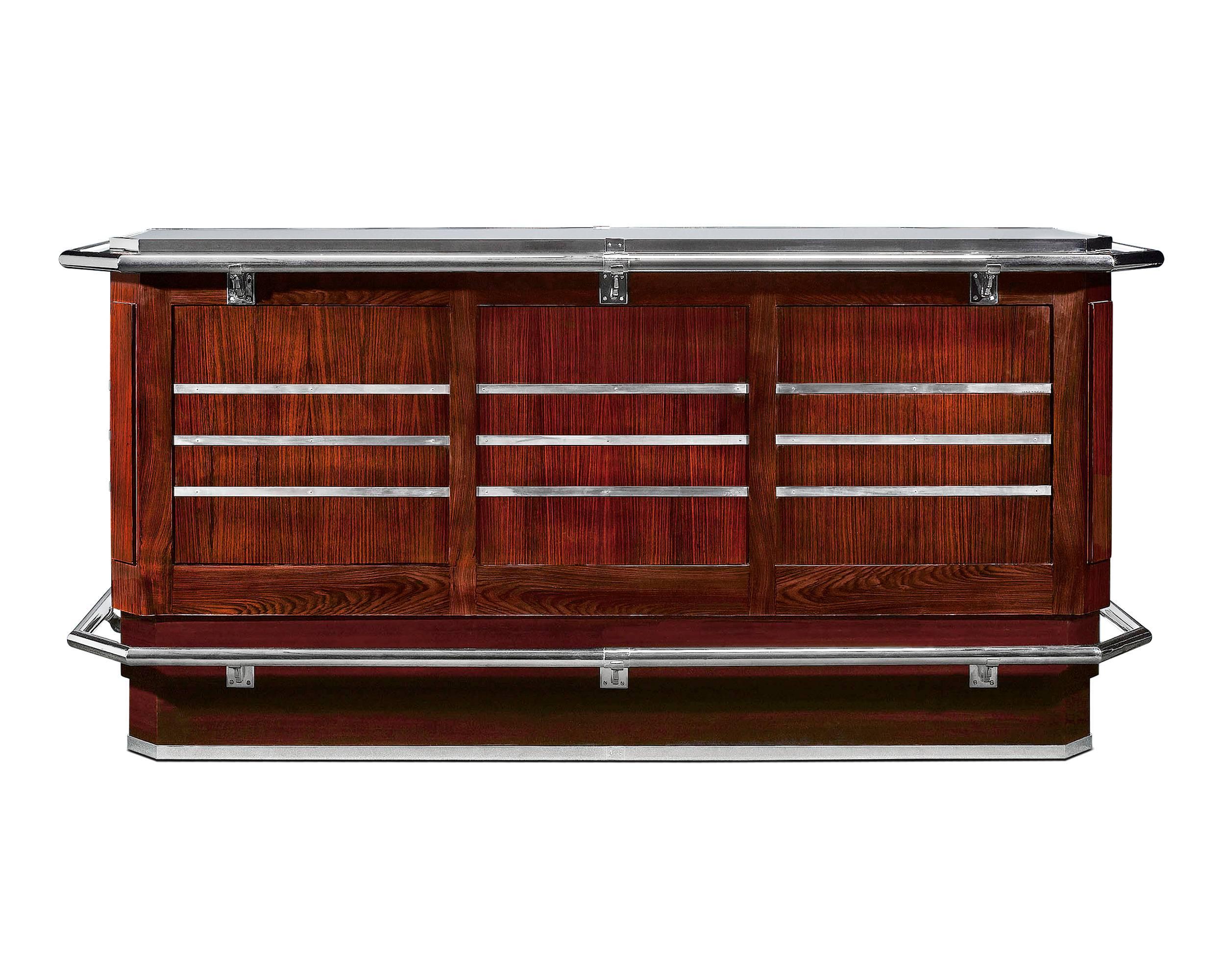 The elegance of the Art Deco era is epitomized in this stunning bar. At almost eight feet long, this remarkable bar displays exceptional proportion. Beautifully crafted of polished mahogany mounted with polished chrome accents, including hand and