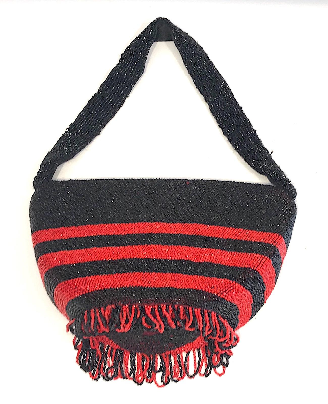 An elegant and chic design 1920s Art Deco handbag in black and red beadwork. The body of the bag is firm with a flat round bottom to maintain its shape when set on a surface. The entire exterior of the bag and top of the 1 inch wide fabric handle