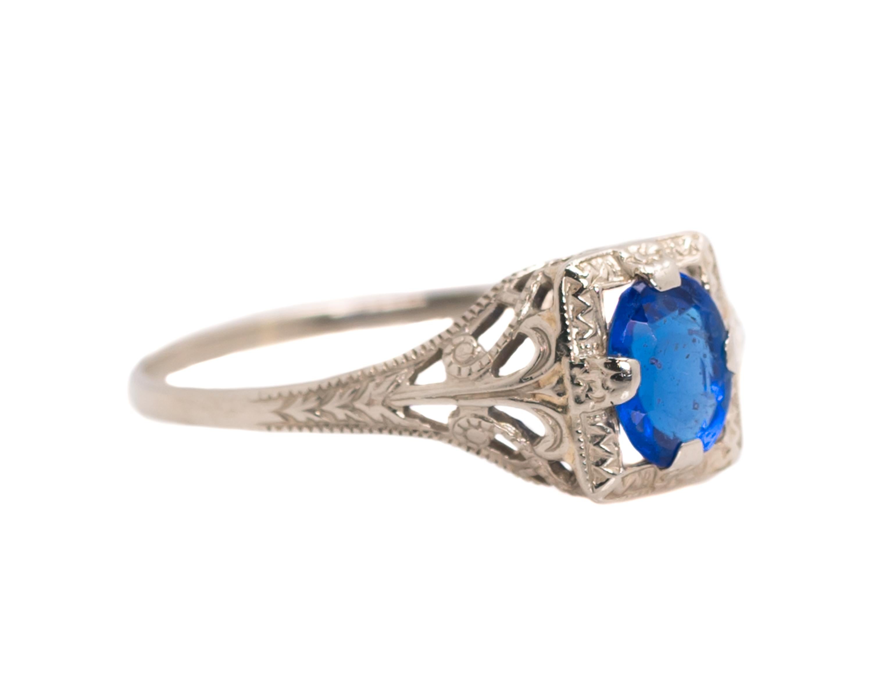 1920s Art Deco Blue Sapphire Ring - 10k White Gold, Simulated Blue Sapphire

Features:
Oval Center Stone in a Square Setting
10 Karat White Gold Filigree Setting with Open Gallery and Shoulders
Fine milgrain detail along the upper and lower edges of