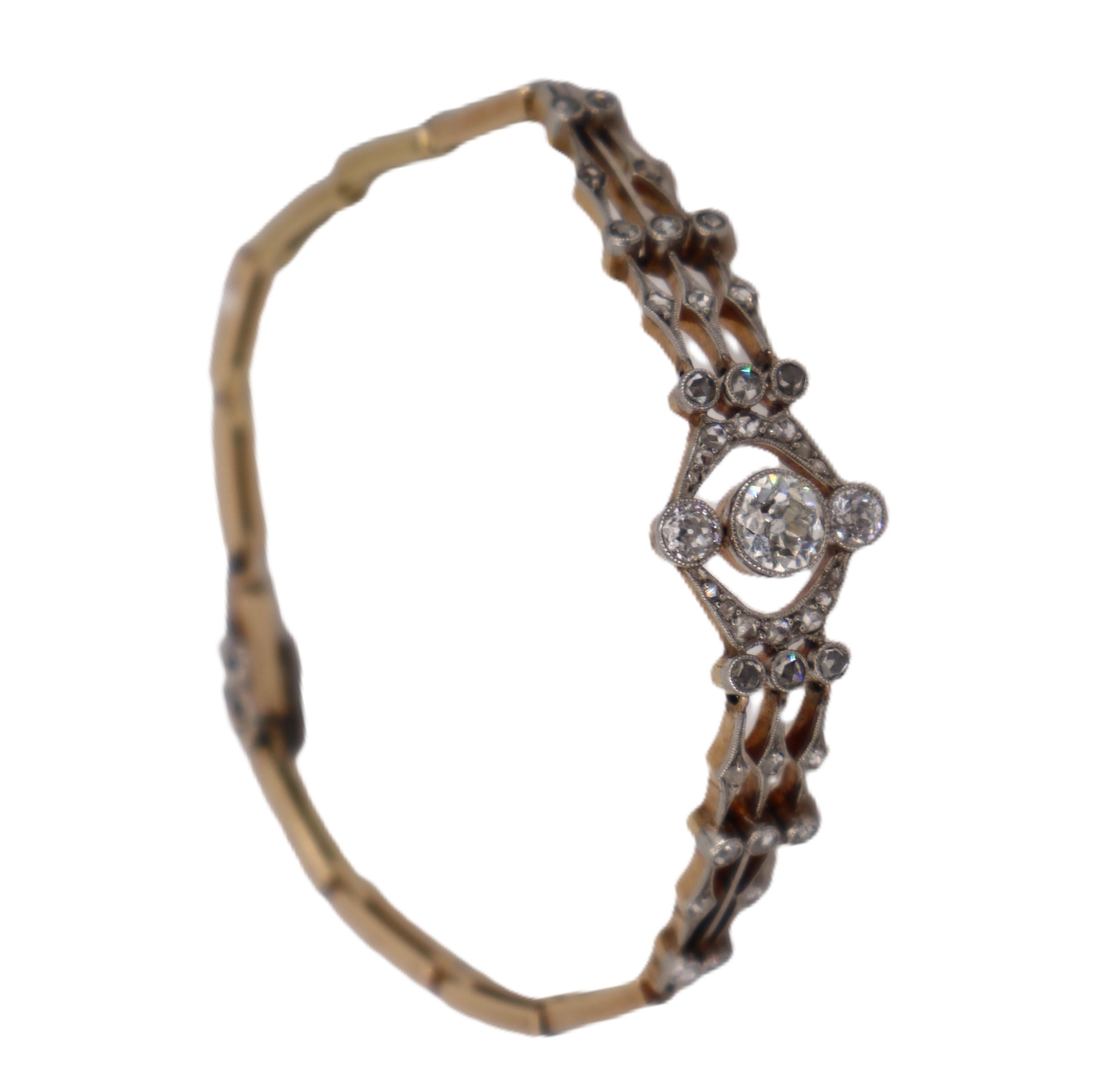 This stunning circa 1920-1930s Art Deco bracelet exemplifies the sophisticated glamour of the Jazz Age, expertly crafted in lustrous 18kt yellow gold with platinum detailing and featuring a magnificent 0.60-carat old mine diamond as its captivating