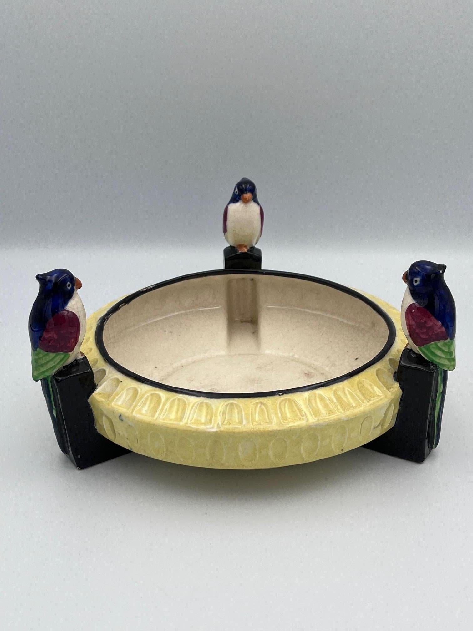 Dieser auffällige Art-déco-Vogelübertopf aus Keramik aus den 1920er Jahren ist ein skulpturales Meisterwerk, das die Vorliebe der Epoche für kräftige Farben, geometrische Formen und exotische Einflüsse verkörpert. In der Mitte des Gefäßes befindet